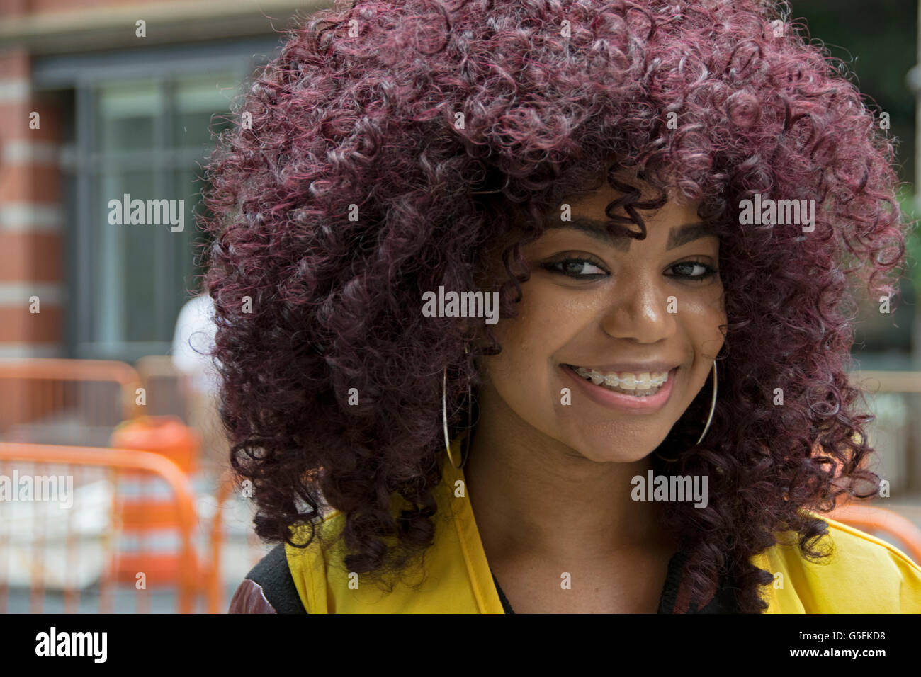 Porträt einer schönen College-Studentin mit einem größeren violett Afro-Frisur. In Greenwich Village, New York City. Stockfoto