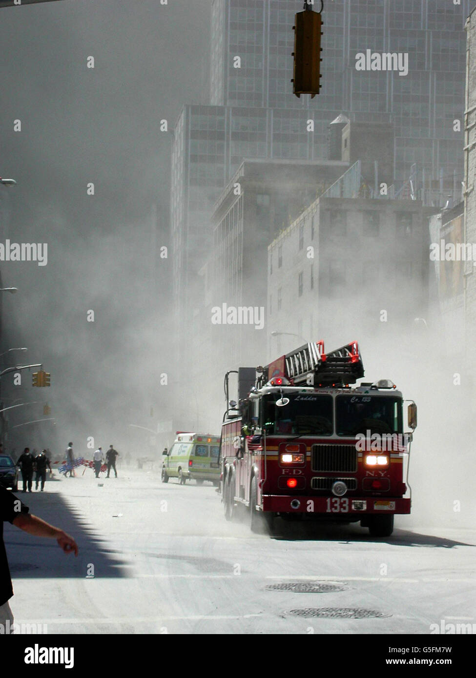 Ein Feuerwehrmotor, der unmittelbar nach der Zerstörung des World Trade Center in New York durch den Staub pflügt, wird vor einer enormen Aufgabe stehen, die Leichen der bei den Angriffen auf das World Trade Center und das US-amerikanische Welthandelszentrum in Washington Getöteten zu Bergen. Stockfoto