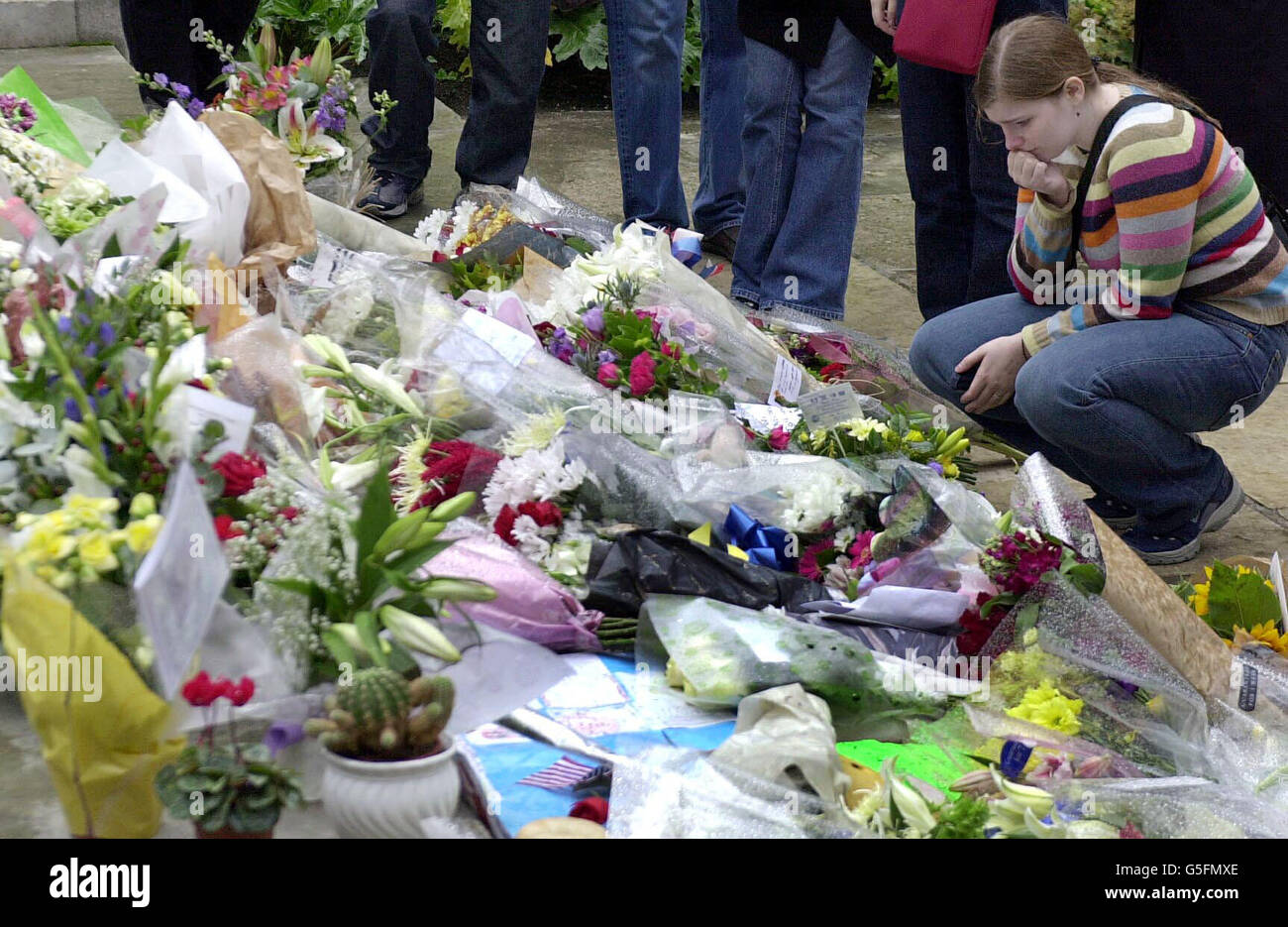 Ein Trauerjäger liest vor der amerikanischen Botschaft im Zentrum von London blumige Ehrungen vor, die an die Opfer der Terroranschläge in New York und Washington erinnert werden. Stockfoto