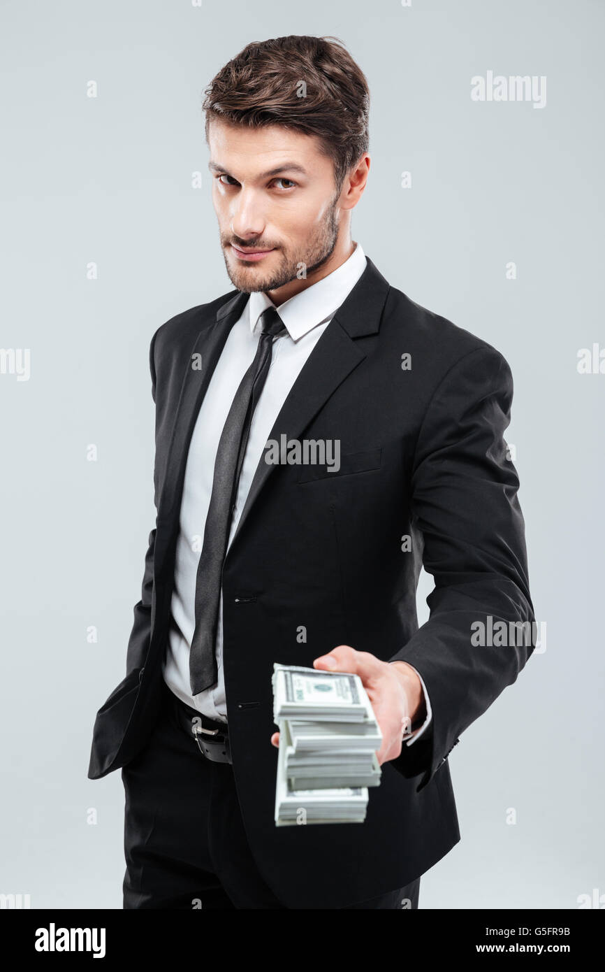 Zuversichtlich Jungunternehmer stehen und geben Ihnen Geld auf weißem Hintergrund Stockfoto