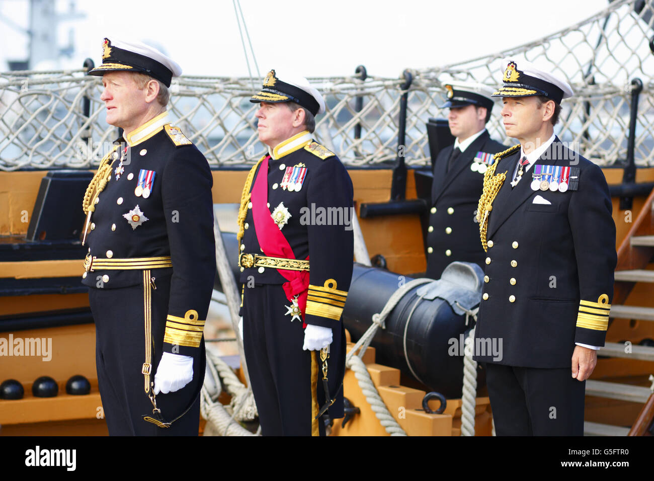 Der zweite Seegott, Vizeadmiral Sir Charles Montgomery (links), beobachtet, wie seine Flagge während einer Zeremonie an Bord der HMS Victory gesenkt wird, um das Flaggschiff formell an den ersten Seegräber, Admiral Sir Mark Stanhope (Mitte), zu übergeben. Die Zeremonie markierte auch die Ankunft des neu ernannten zweiten Seegords, Vizeadmiral David Steel (rechts), der Montgomery ersetzt. Stockfoto