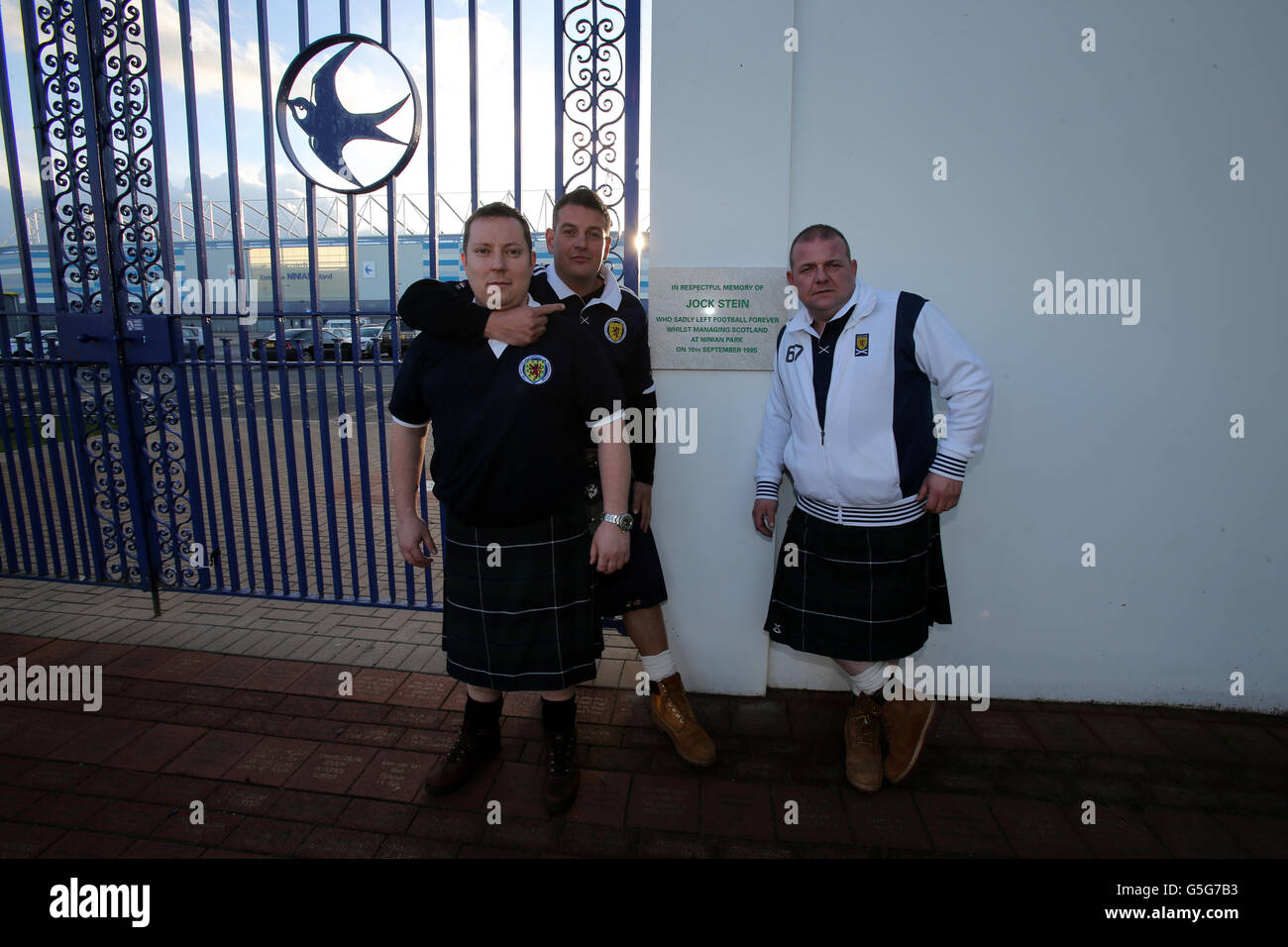 Schottland-Fan Gordon Young und Freunde Graham und Tony an den alten Ninian Park Gates mit der Gedenktafel zum Gedenken an den ehemaligen schottischen Manager Jock Stein vor dem FIFA-WM-Qualifikationsspiel 2014 im Cardiff City Stadium, Cardiff. Stockfoto