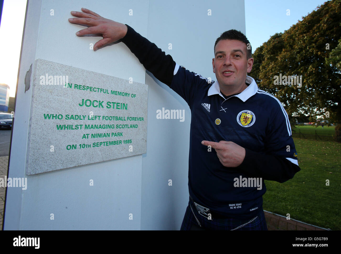Schottland-Fan Gordon Young an den alten Ninian Park Gates mit der Gedenktafel an den ehemaligen schottischen Manager Jock Stein vor dem FIFA-WM-Qualifikationsspiel 2014 im Cardiff City Stadium, Cardiff. Stockfoto