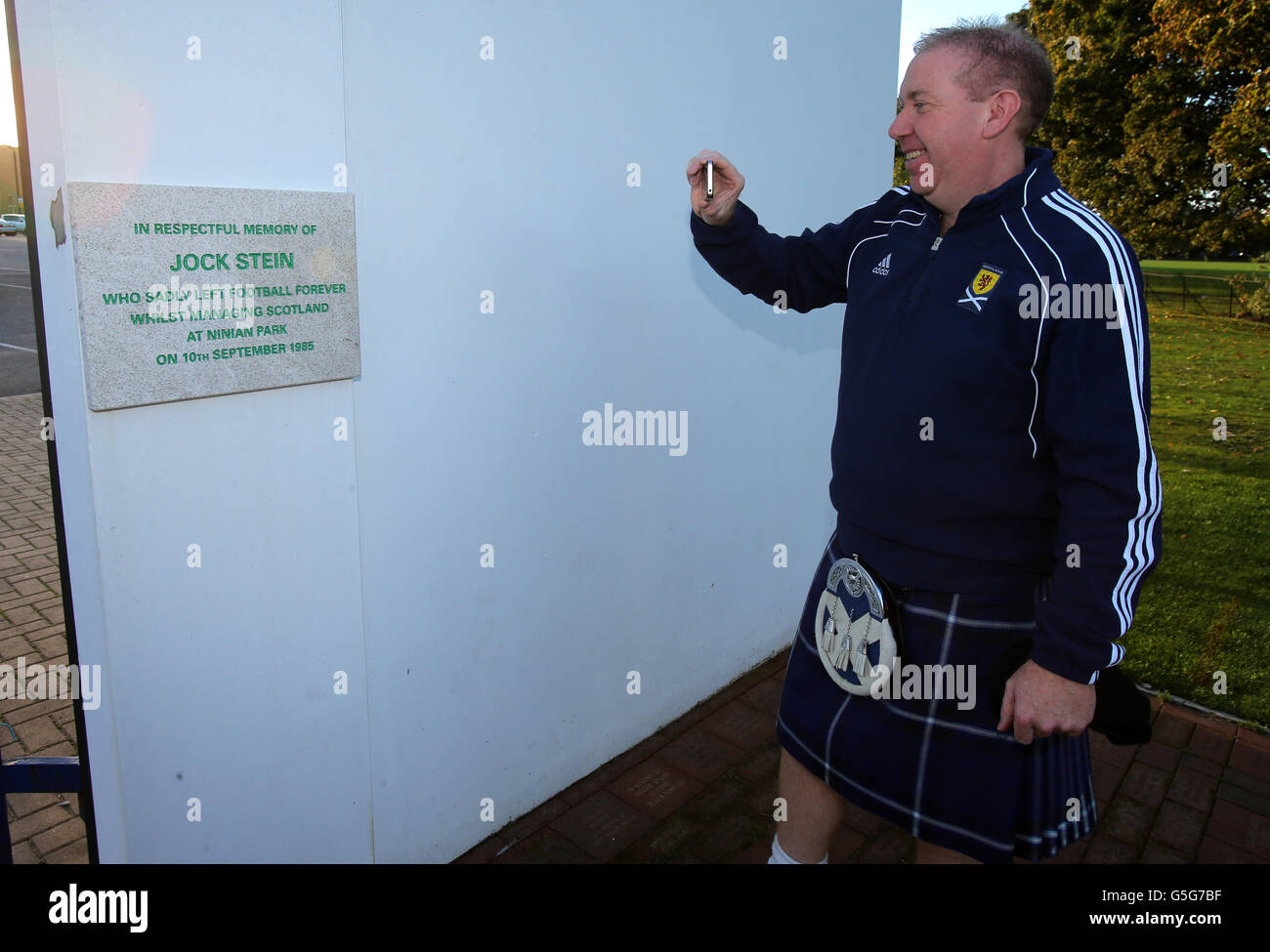 Schottland-Fan Gary Holden an den alten Ninian Park Gates mit der Gedenktafel an den ehemaligen Schottland-Manager Jock Stein vor dem FIFA-WM-Qualifikationsspiel 2014 im Cardiff City Stadium, Cardiff. Stockfoto
