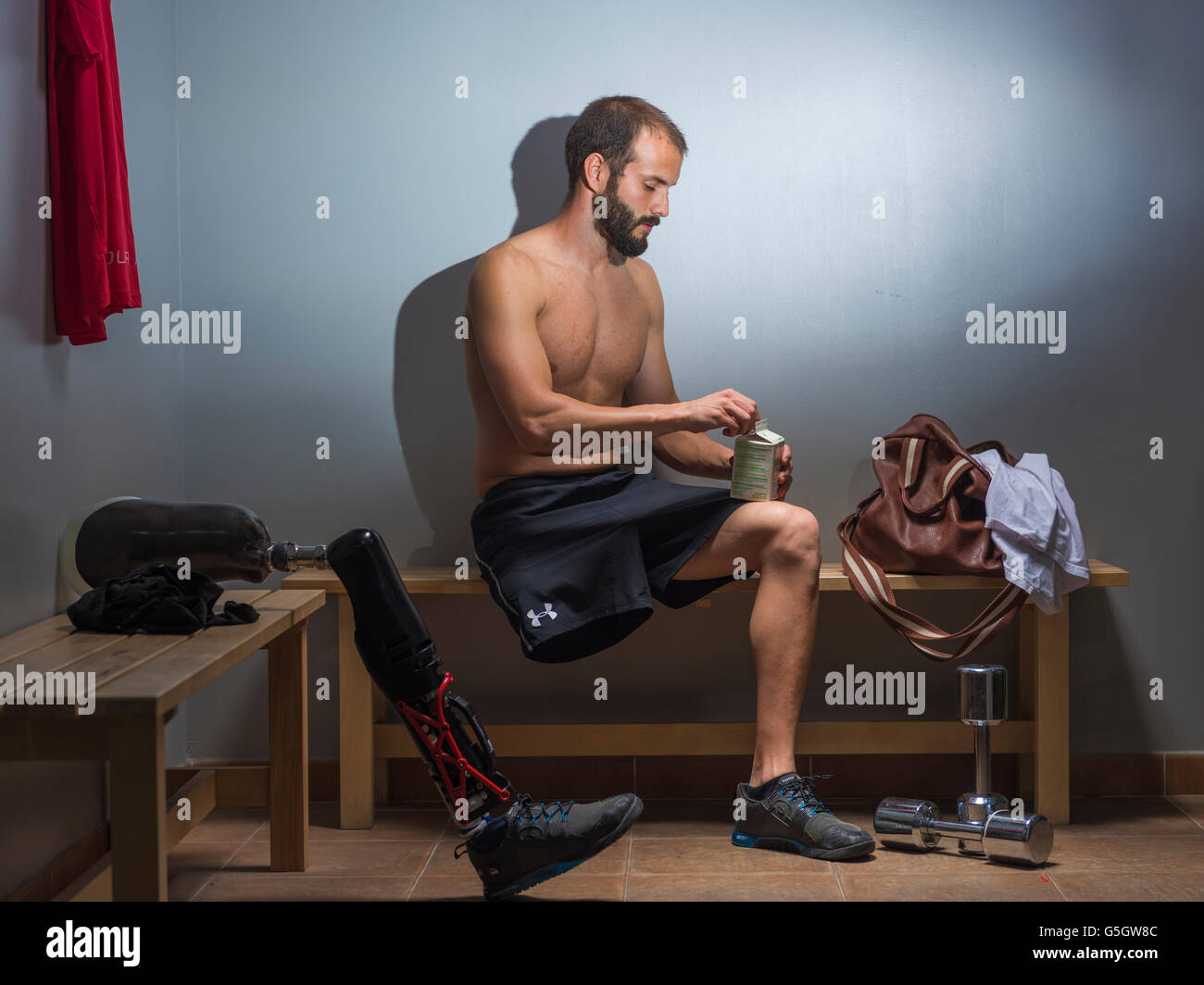 Mann mit einer Prothese in der Umkleide der Turnhalle. Stockfoto