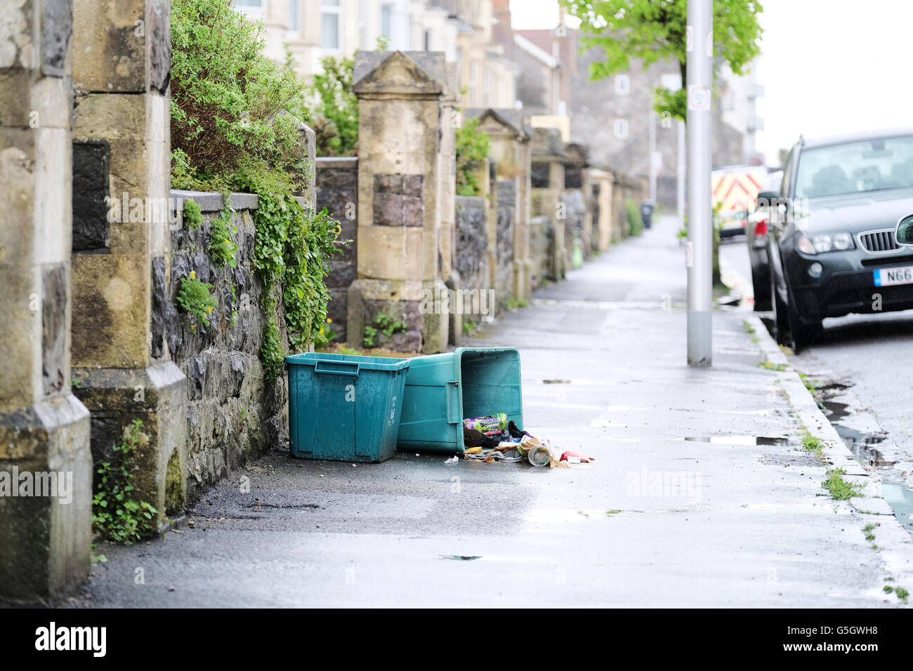 Ein lokaler Rat Whirlpool recycle ist umgekippt auf der Straße. Der Papierkorb auf dem Gehsteig ausgebreitet haben Stockfoto