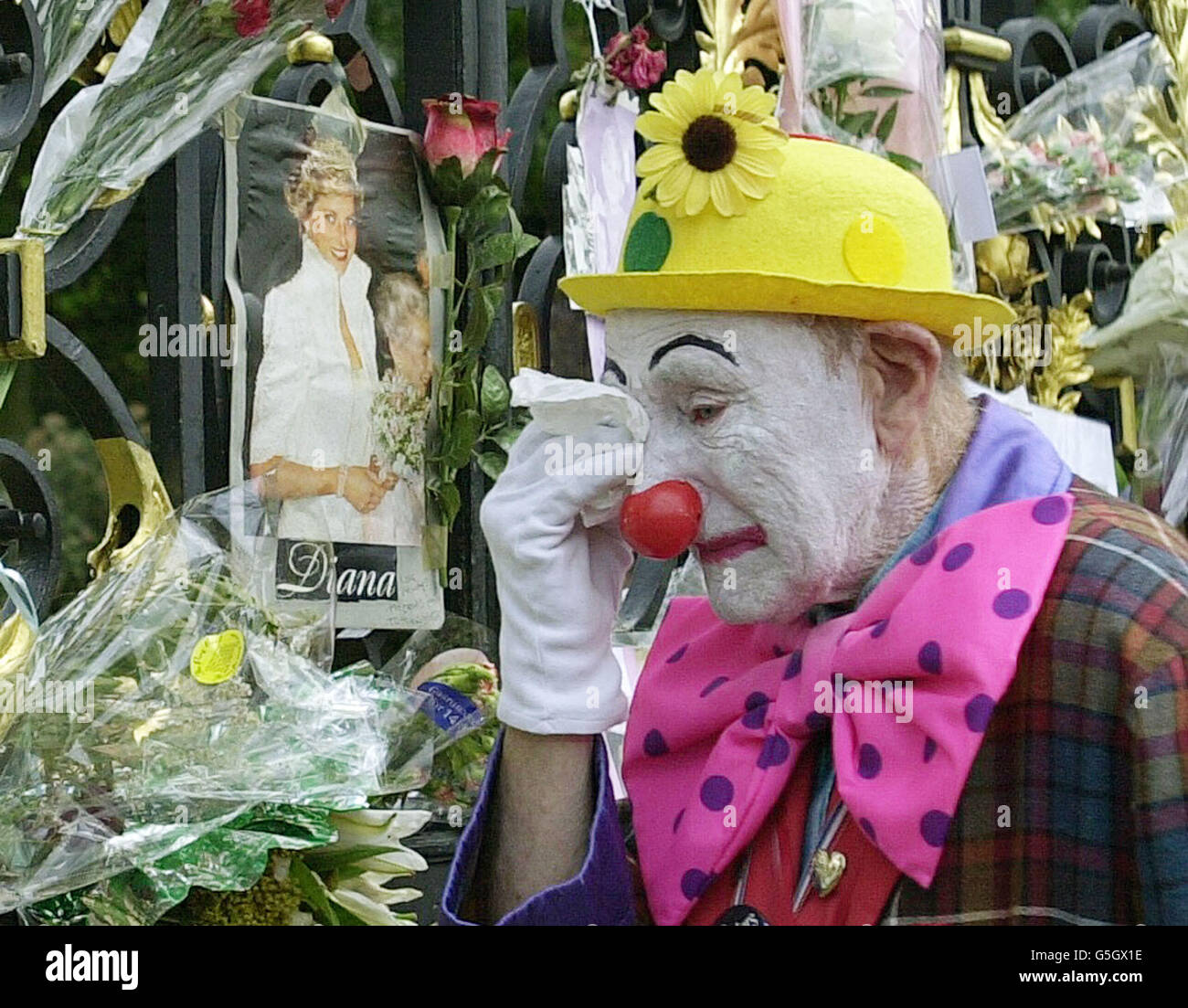 Ein Clown schreit vor den Toren des Kensington Palace, der ehemaligen Londoner Residenz der vor vier Jahren verstorbenen Prinzessin von Wales. Die Tore sind mit Blumen und Karten geschmückt, um an die Prinzessin zu erinnern, die 1997 bei einem Autounfall in Paris starb. Stockfoto
