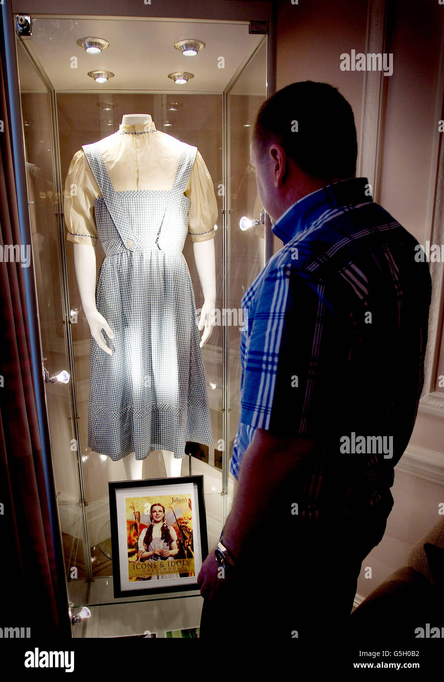 Darren C. Julien von Julien's Auctions überprüft das Kleid, das Judy Garland im Film „der Zauberer von Oz“ trug. Das Kleid wird im Stafford Hotel in London ausgestellt, bevor es am 9. Und 10. November in Beverly Hills bei der Icons and Idols-Veranstaltung versteigert wird. Stockfoto