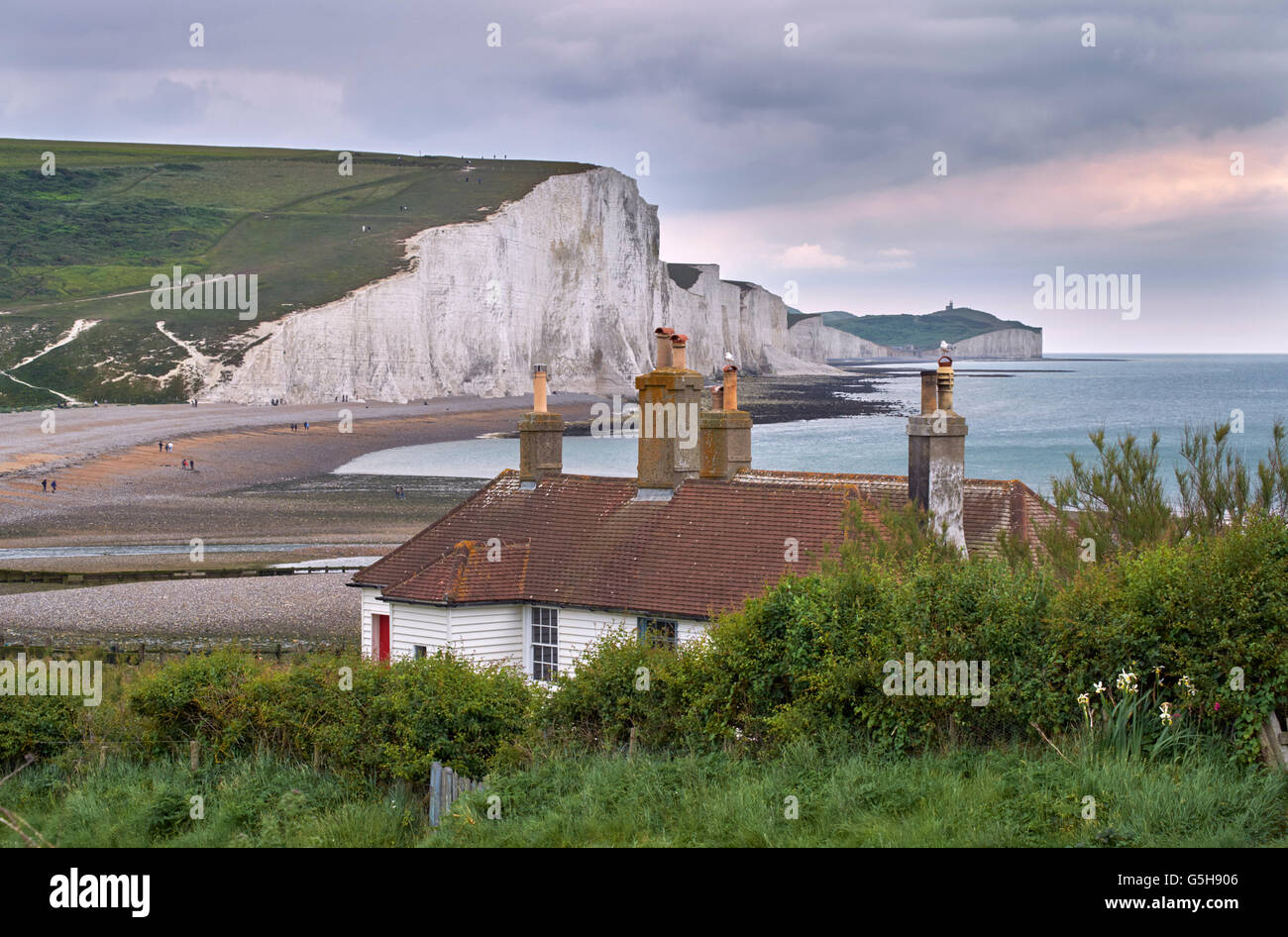 Coastguard Cottages im Seaford Kopf über dem Cuckmere River, mit den sieben Schwestern darüber hinaus. Sussex, England. Stockfoto