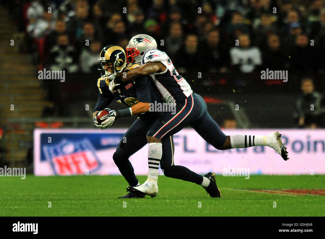 Austin Pettis von St. Louis Rams wird vom New England Patriots' Tavon Wilson während des Spiels der NFL International Series im Wembley Stadium, London, angegangen. Stockfoto