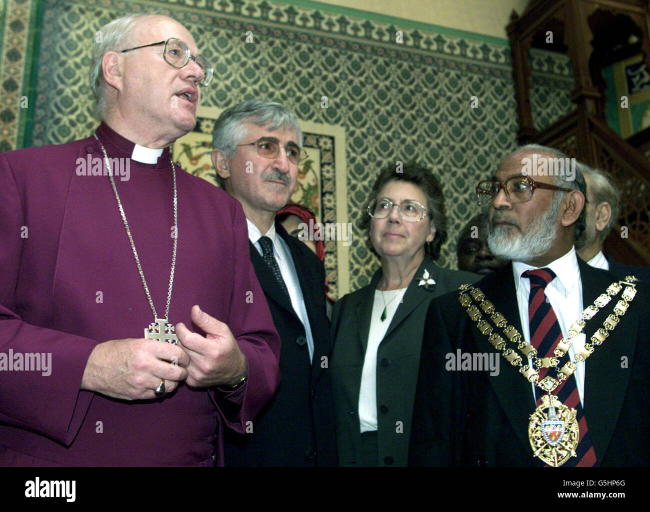 Der Erzbischof von Canterbury, George Carey (links), spricht, während er von dem Vorsitzenden der Moschee Ilhami Yumak (2. Links) auf eine Tour durch die Sulyemaniye Moschee in Shoreditch, Ost-London, mitgenommen wird. * .... Der Erzbischof erläuterte seine Entschlossenheit, dass der christliche und muslimische Glaube zusammenarbeiten und friedlich nebeneinander leben soll. Stockfoto