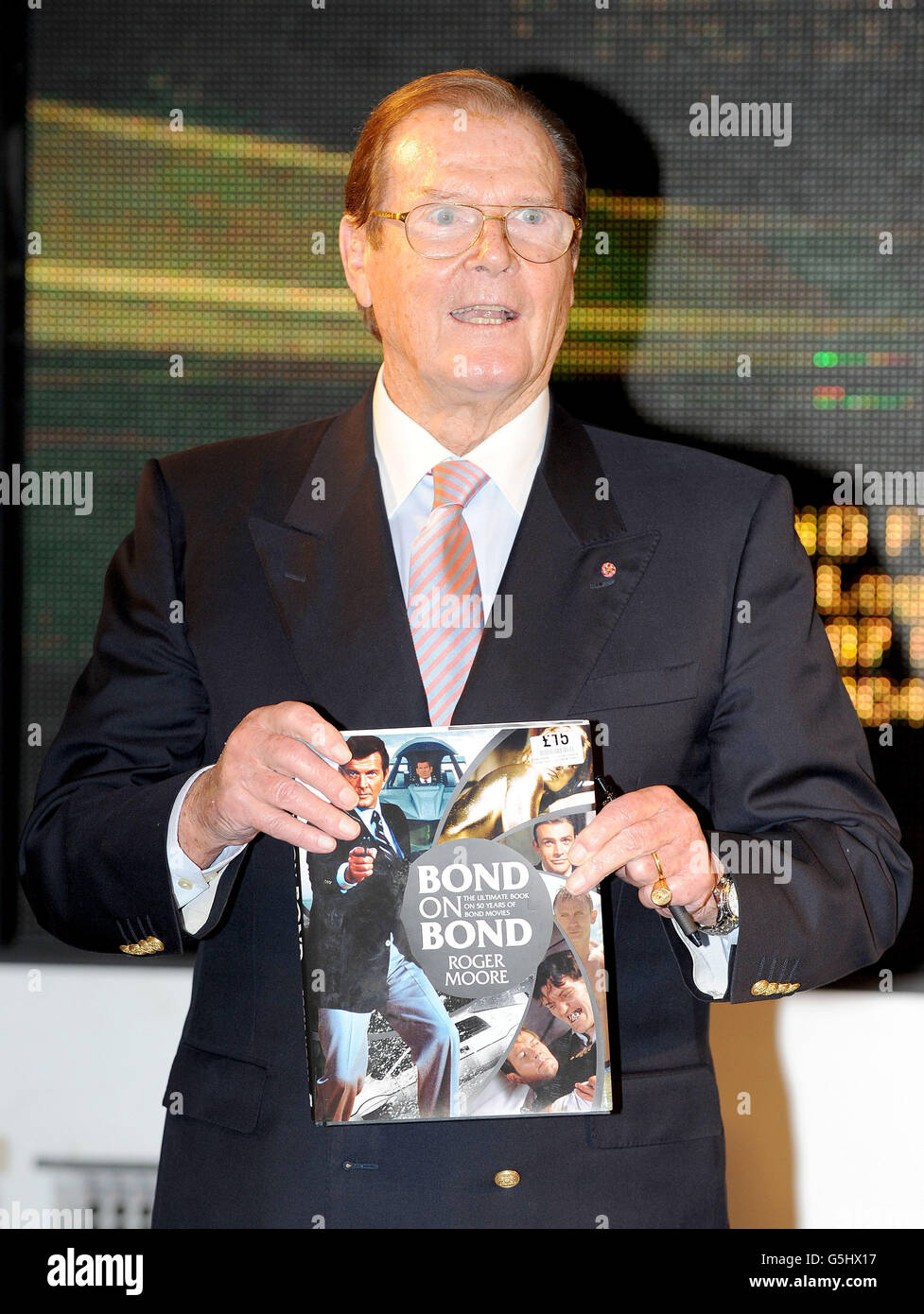 Sir Roger Moore hält eine Kopie seines neuen Buches Bond on Bond, während einer Buchunterzeichnung im HMV in der Oxford Street, London. Stockfoto