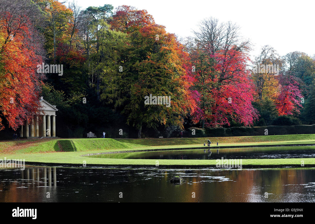Letzte Blüte der Herbstfarben als Kinder auf Halbzeit Urlaub Spaziergang zwischen den spektakulären späten Farben auf den Bäumen in Fountains Abbey in der Nähe von Ripon. Stockfoto