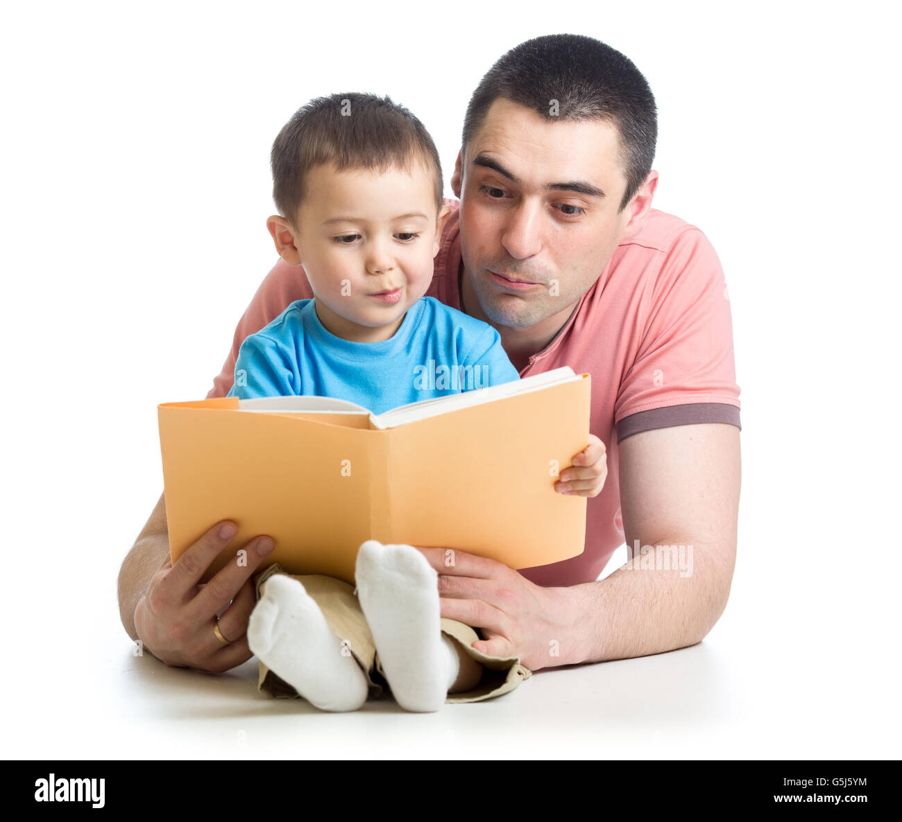 Kid Boy und Vater lesen ein Buch am Boden zu Hause Stockfoto