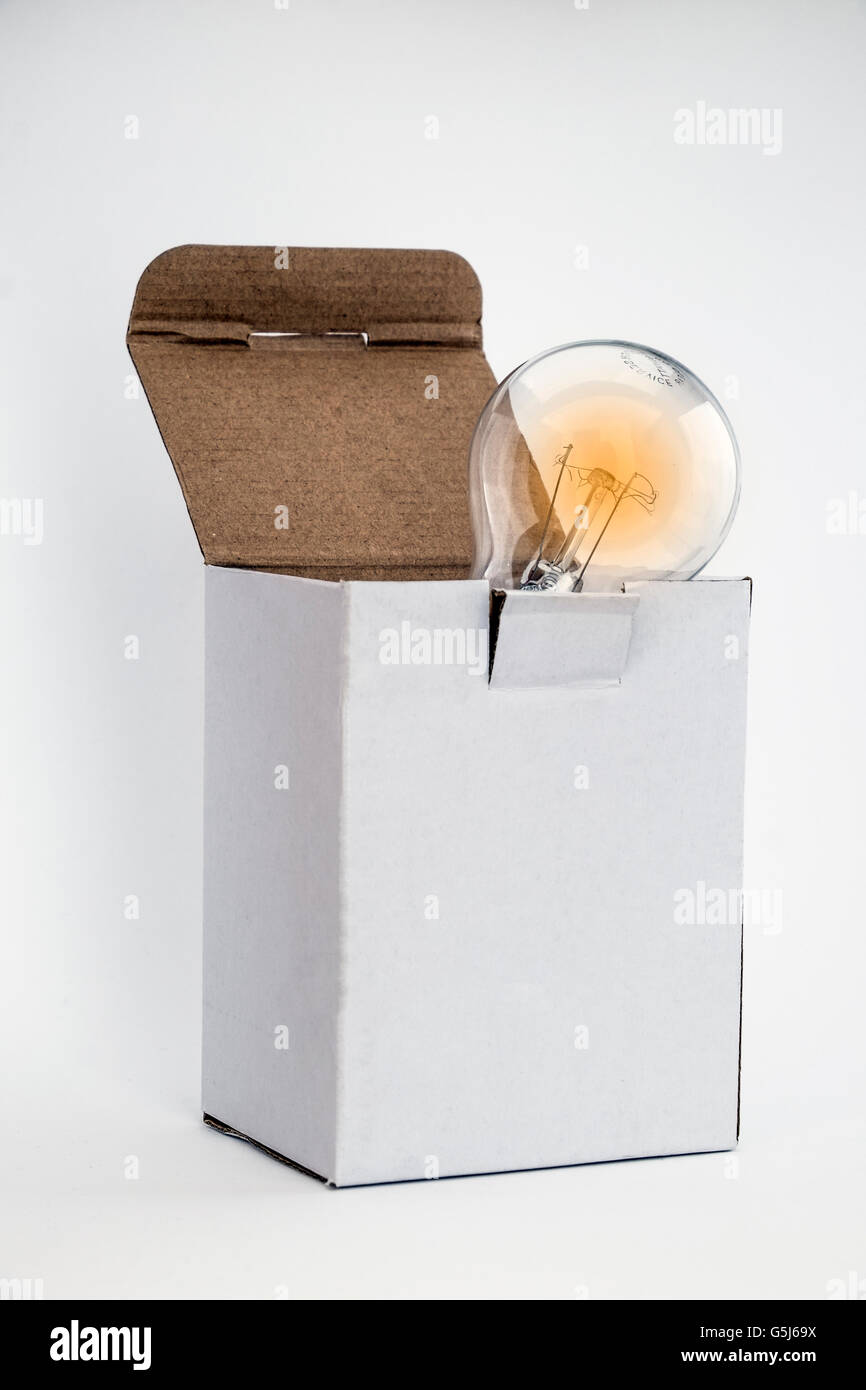 Leuchtende Glühbirne im weißen Kasten bedeutet denken außerhalb der Box-Konzept mit Platz für Text auf Box und weißem Hintergrund Textfreiraum Stockfoto