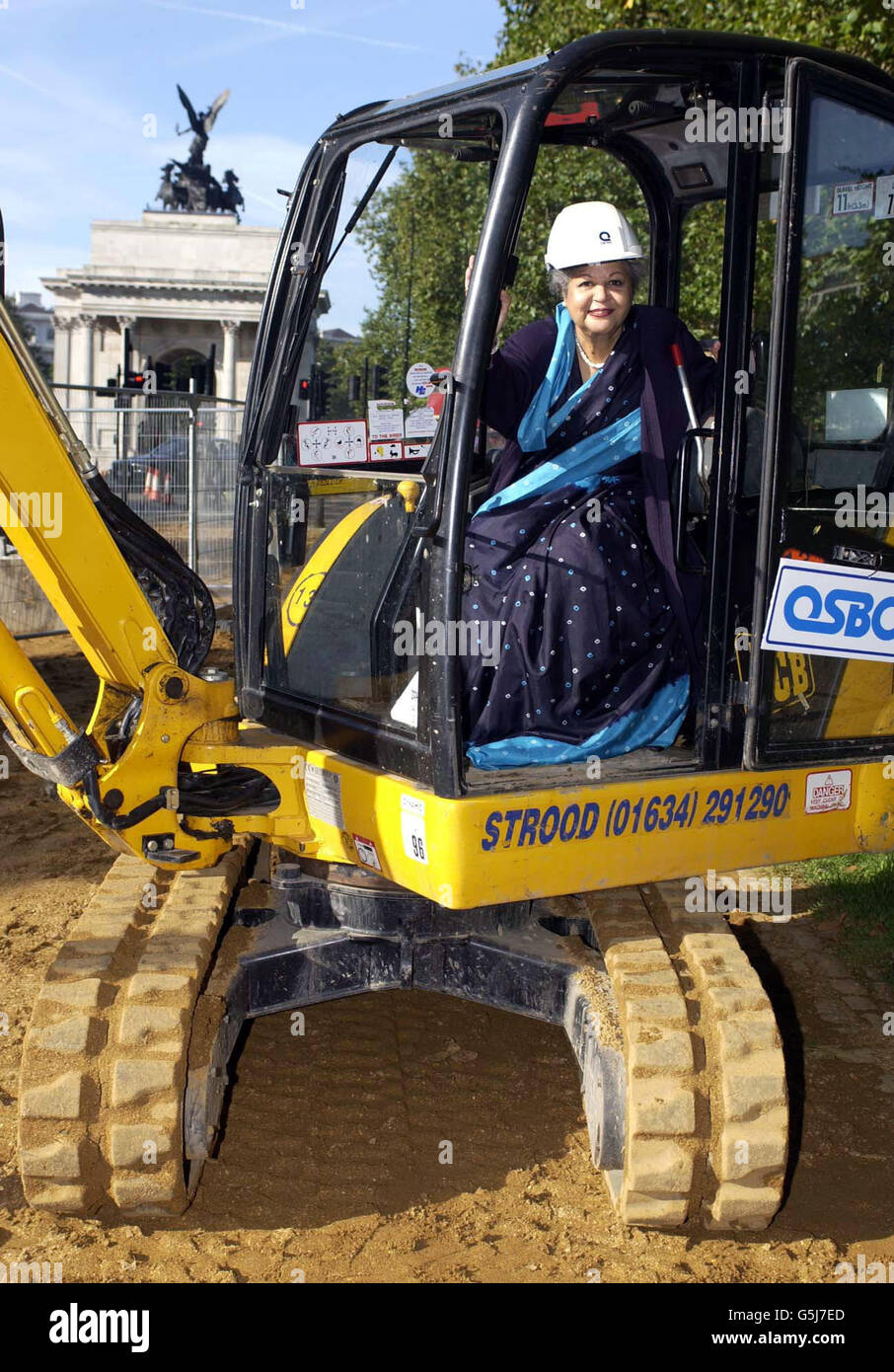 Baroness Flather, Vorsitzende des Memorial Gates Trust, in einem Bagger, der zu Beginn des Baus der zeremoniellen Tore auf dem Constitution Hill in London für einen feierlichen Spatenstich verwendet wurde. * die Tore werden der Rolle von fünf Millionen Männern und Frauen aus dem indischen Subkontinent, Afrika und der Karibik gedenken, die während der beiden Weltkriege als Freiwillige bei den britischen Streitkräften tätig waren. Stockfoto