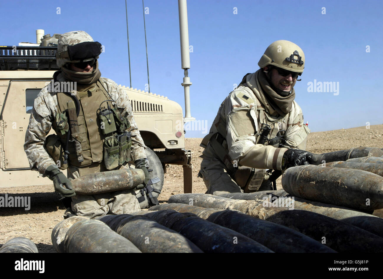 Marines und Matrosen Stapeln Raketen, Mörser und Taschen von Insektenspray. Stockfoto