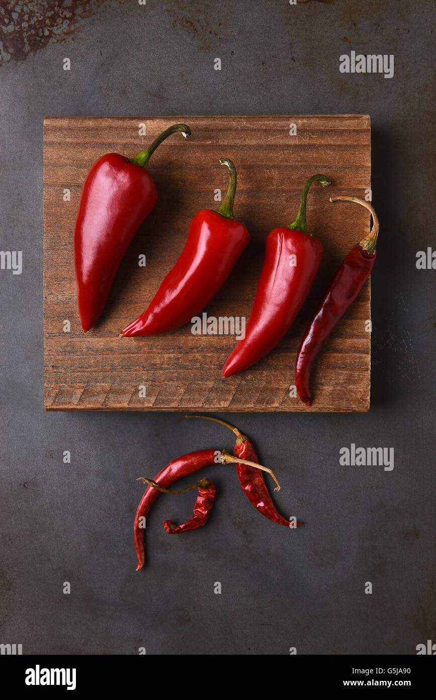 Frische und getrocknete Chilis auf ein Schneidebrett und Metall Backblech legen. Stockfoto