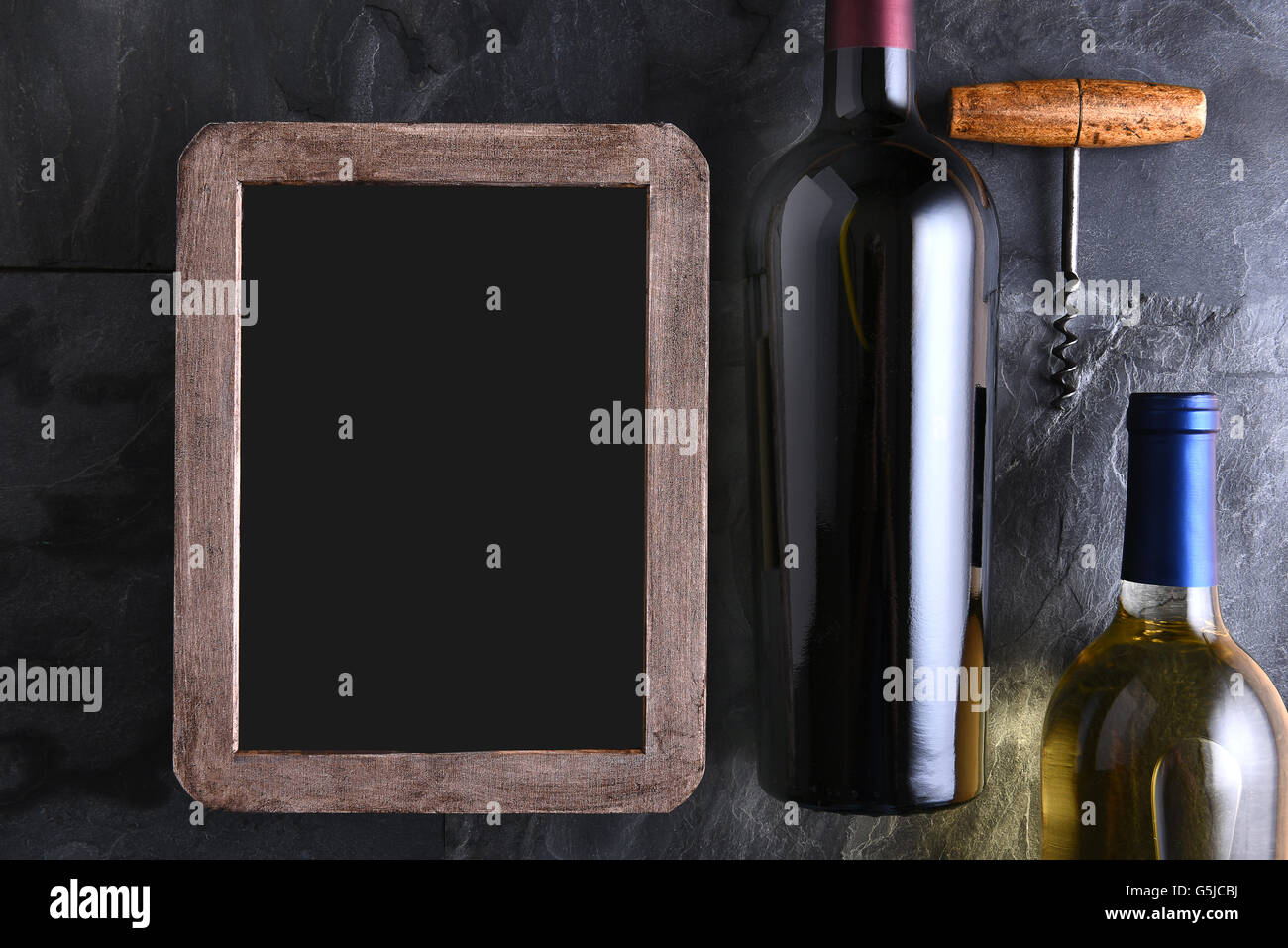 Draufsicht der zwei Flaschen Wein und Korkenzieher neben einem leeren Kreide Board Wein Liste. Stockfoto