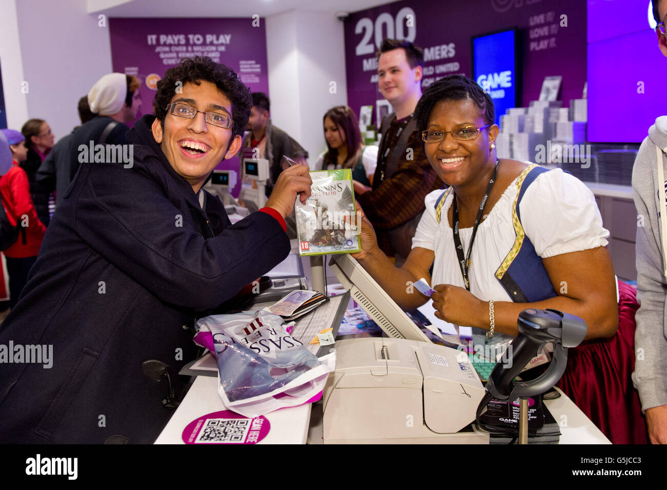 Zohaib Ali aus Uxbridge kauft als erster ein Exemplar von Assassins Creed III im Londoner Flagship-Store in Stratford, der um Mitternacht eröffnet wurde, damit die Fans gleich nach der Veröffentlichung des Spiels ein Exemplar erhalten können. Stockfoto