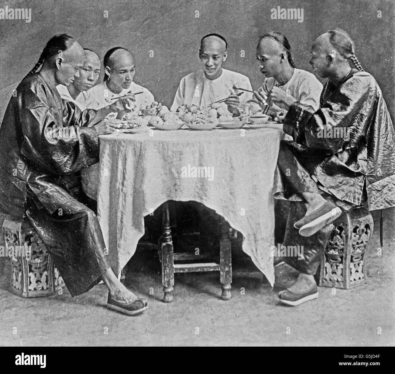 Chinesen Bei Einer Brauches, doppelstrebig aus Nudeln Und Dim-Su, China 1910er Jahre. Chinesen nehmen eine Mahlzeit aus Nudeln und Dim-Sum-Knödel, China 1910er Jahre. Stockfoto