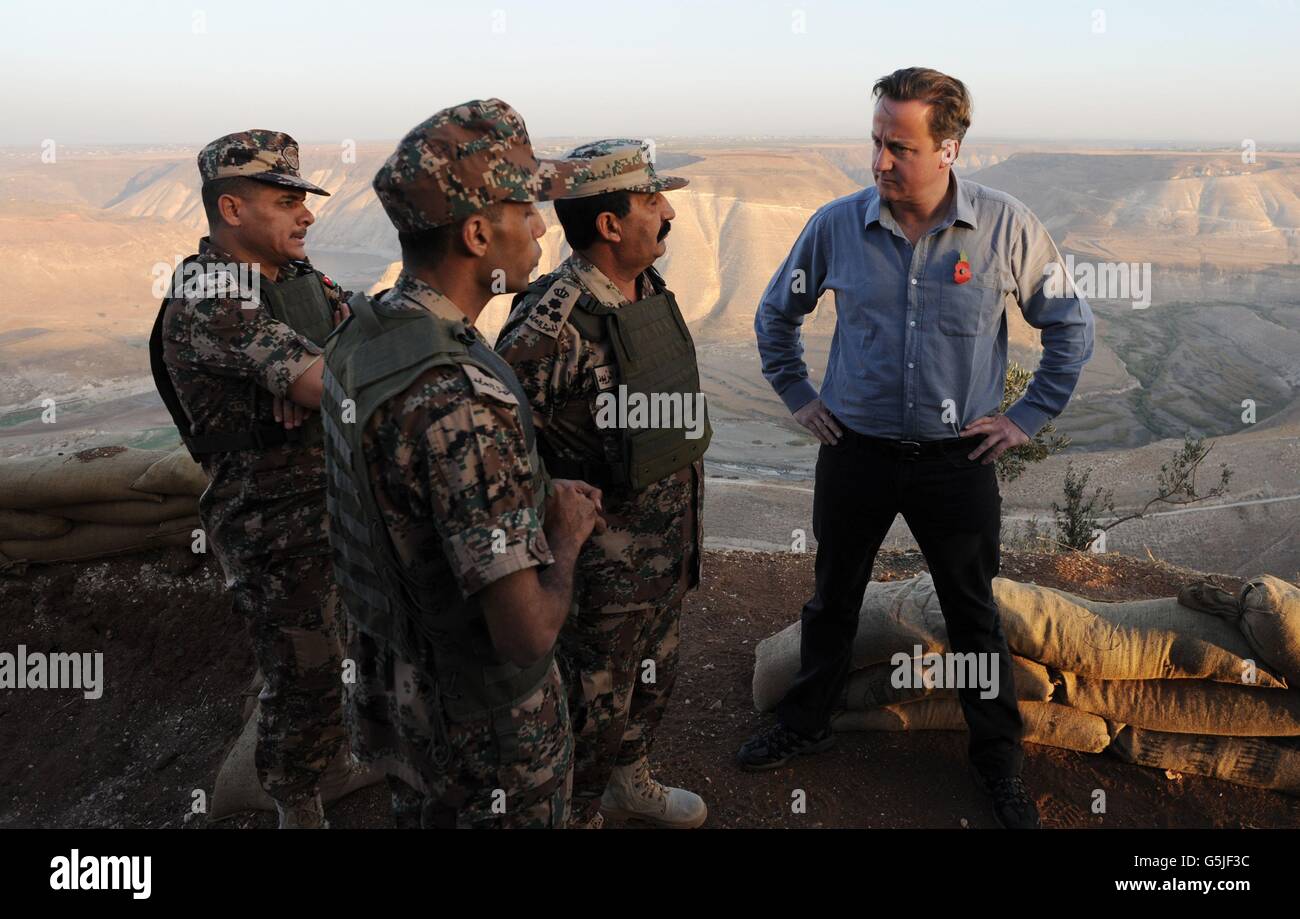 Premierminister David Cameron spricht mit Grenzschutzbeamten an der syrisch-jordanischen Grenze in der Nähe des Al Wahdah-Staudamms. Cameron sah den Weg der syrischen Flüchtlinge und ging später ins Za'atri-Lager und traf syrische Familien, die über die Grenze geflohen sind. Stockfoto