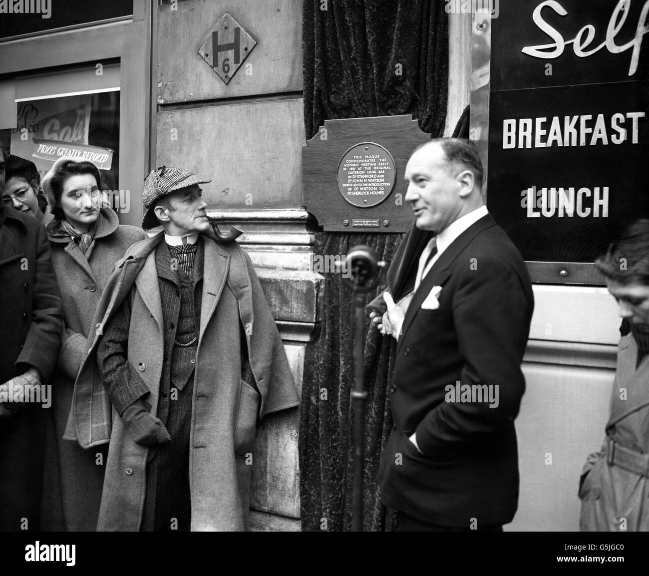 Der englische Schauspieler Carleton Hobbs, gekleidet als Sherlock Holmes, mit dem Ex-Chefinspektor Fabian von Scotland Yard, erlebt die Enthüllung einer Tafel, auf der das Treffen seiner Figur mit Dr. Watson in der Long Bar im Criterion Restaurant im Piccadilly Circus, London, im Jahr 1851 aufgezeichnet wurde. Die Gedenktafel ist das Geschenk der Tokio Sherlock Holmes Society. Stockfoto