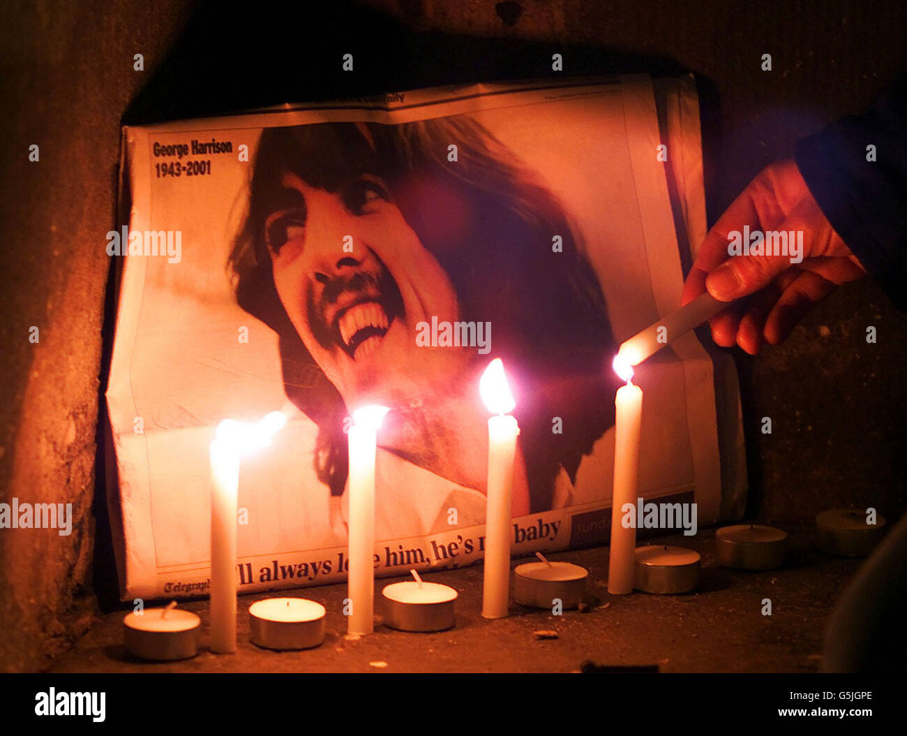 Kerzen werden vor einem Bild des ehemaligen Beatle-Gitarristen George  Harrison angezündet, der während einer Kerzenlicht-Mahnwache vor der St  George's Hall, Liverpool, starb. * Mehr als 1000 Menschen nahmen an der  Veranstaltung Teil,