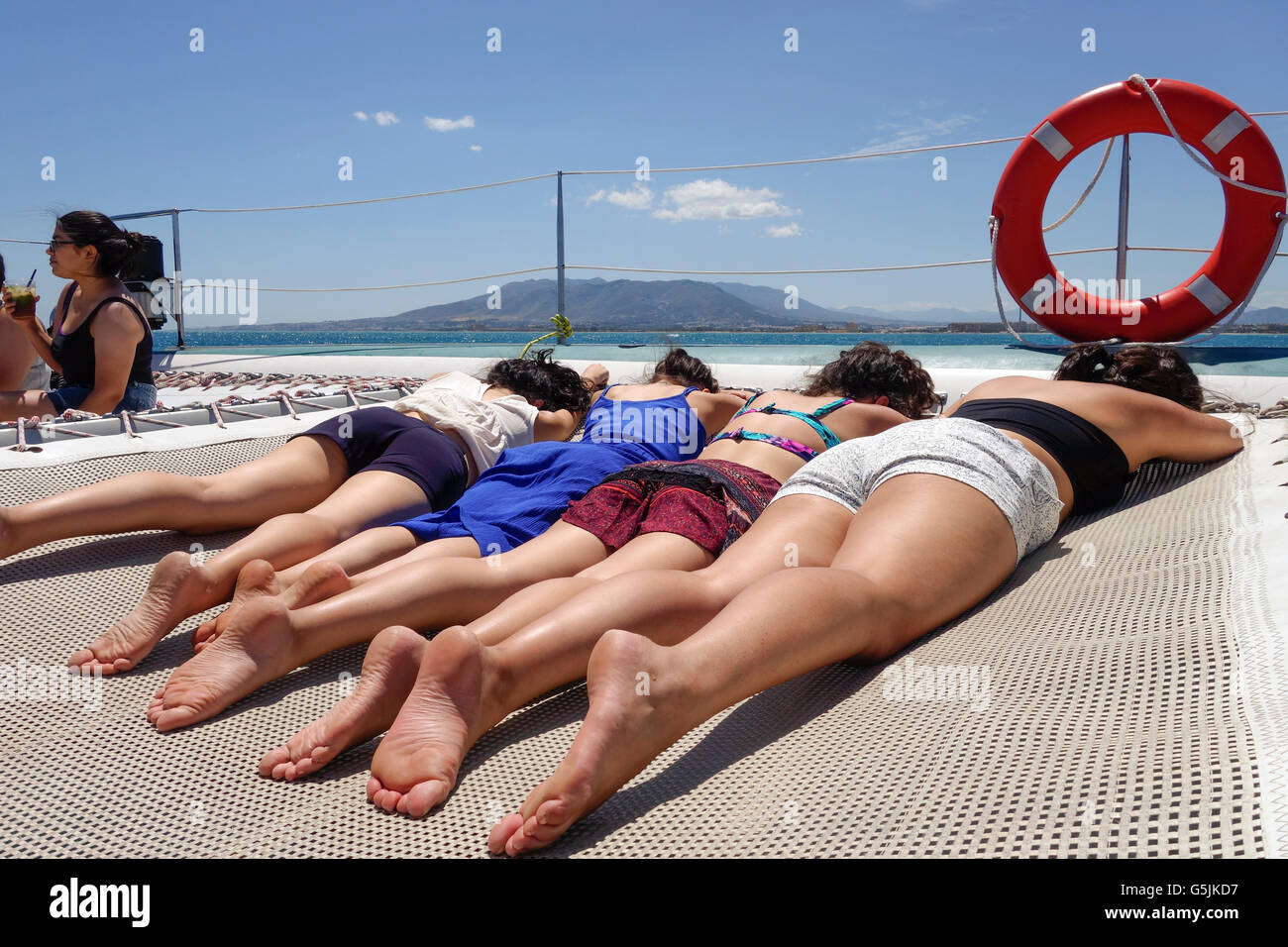 Gruppe von weiblichen Jugendlichen Sonnen auf Katamaran, Segelboot-Tour und genießen Sie Sonne, Malaga, Andalusien, Spanien. Stockfoto