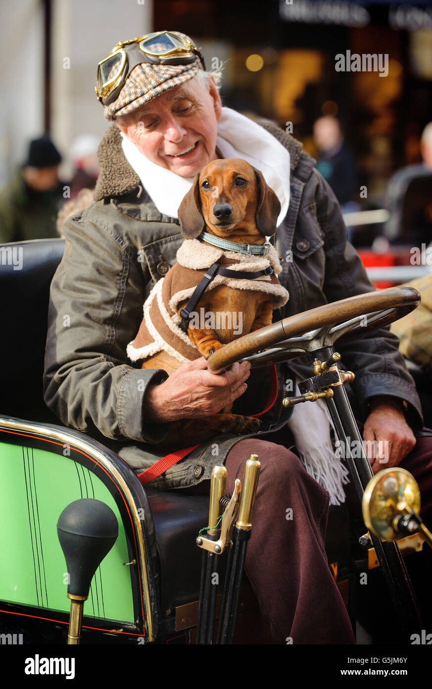 Cliff Jowsey und sein Hund Rolo sitzen auf der Regent Street Motor Show im Zentrum von London in seinem Renault-Auto aus dem Jahr 1902, das neben klassischen Sportwagen und energiesparenden Fahrzeugen 1905 Fahrzeuge aus der Zeit vor 100 bietet. Stockfoto
