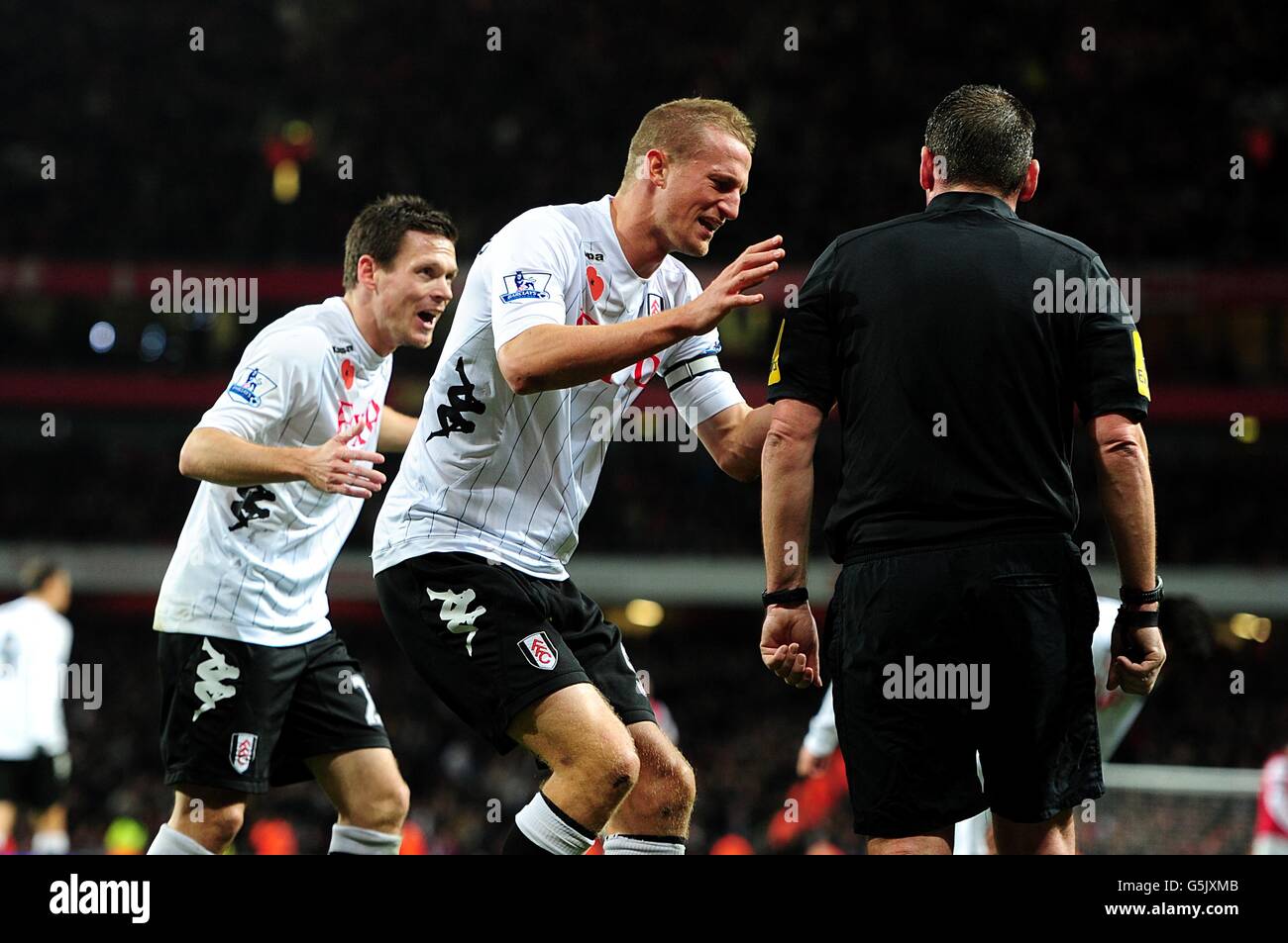 Fußball - Barclays Premier League - Arsenal gegen Fulham - Emirates Stadium. Fulhams Sascha Riether (links) und Brede Hangeland (Mitte) appellieren an Schiedsrichter Phil Dowd (rechts) Stockfoto
