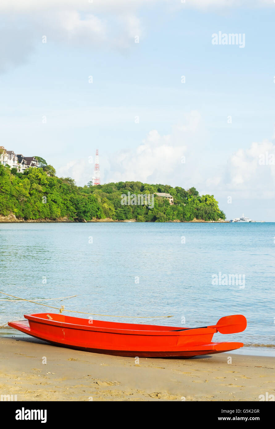 Orange Boot auf dem Sandstrand mit blauem Meer und Himmel Hintergrund im Abendlicht Stockfoto