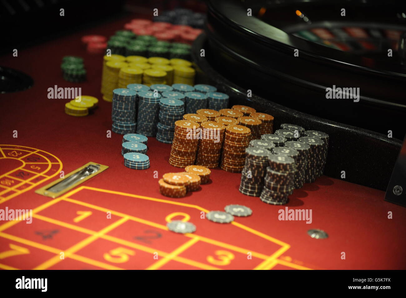 Roulette-Chips liegen auf der Seite ein Roulette-Rad in einem Casino High Street. Stockfoto