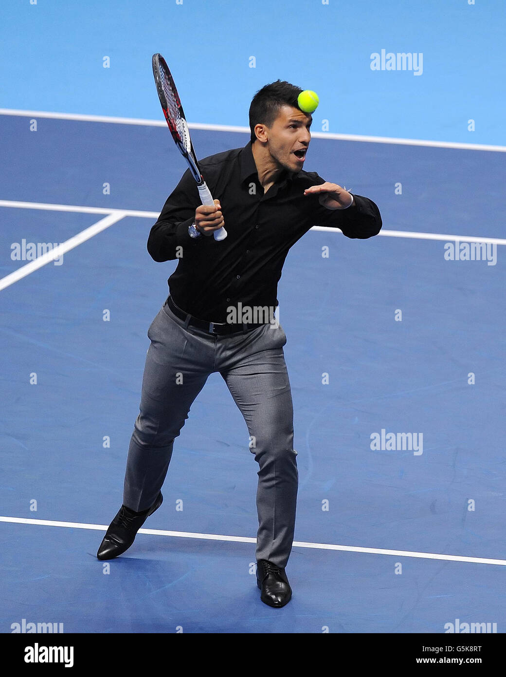 Manchester City Stürmer Sergio Aguero führt einen Tennisball an, während er mit dem Argentinier Juan Martin del Potro Tennis spielt (nicht abgebildet), nachdem del Potros Spiel gegen Serbiens Janko Tipsarevic während der Barclays ATP World Tour Finals in der O2 Arena in London stattfand. Stockfoto