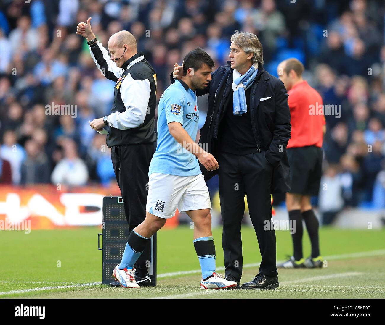 Fußball - Barclays Premier League - Manchester City / Tottenham Hotspur - Etihad Stadium. Sergio Aguero (Mitte) von Manchester City erhält von seinem Manager Roberto Mancini ein Kopfklopfen, nachdem er ersetzt wurde Stockfoto