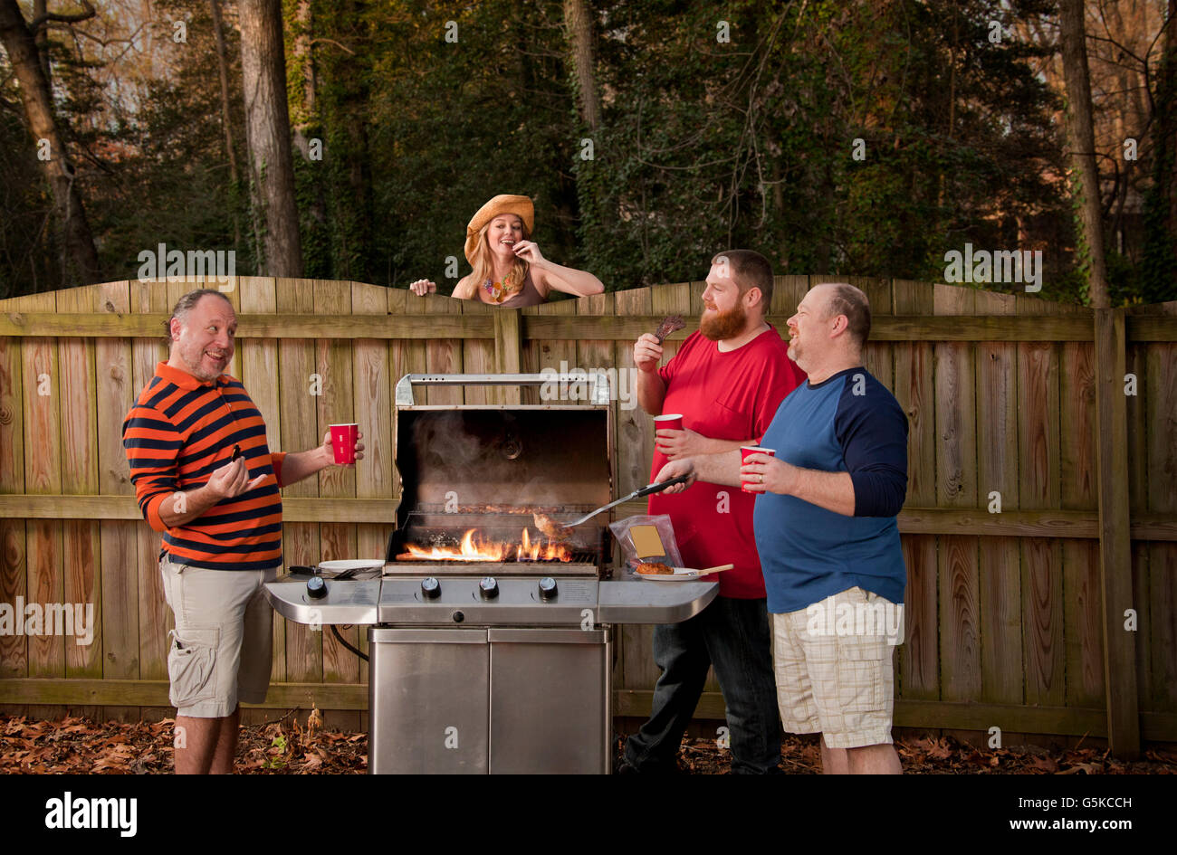 Frau beobachten Nachbarn Grillen Essen Stockfoto