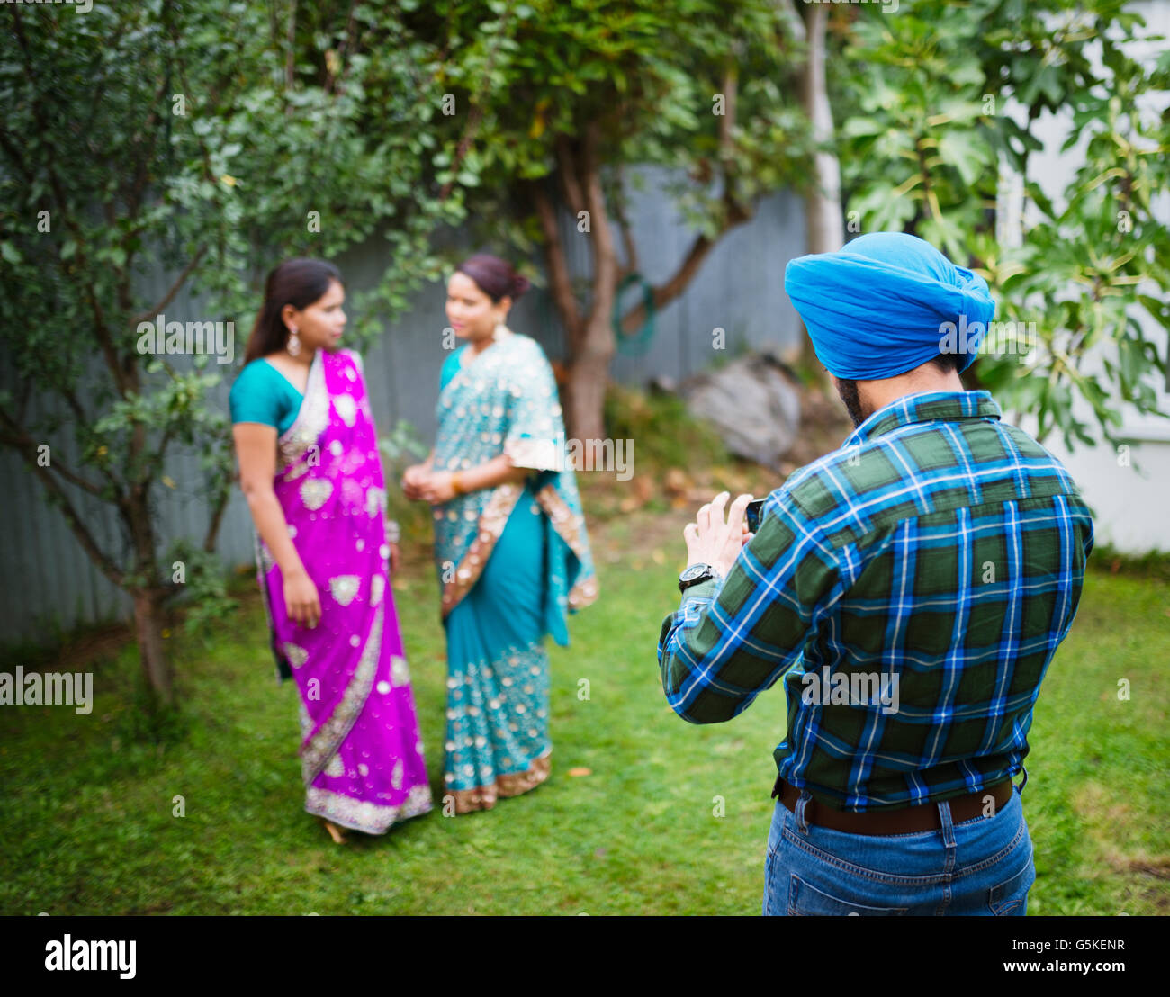 Mann, die Frauen in der traditionellen indischen Kleidern fotografieren Stockfoto