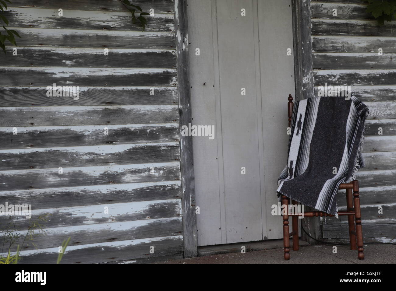 Scheune Bauholz grauen Abstellgleis mit indischen Decke auf Stuhl Stockfoto