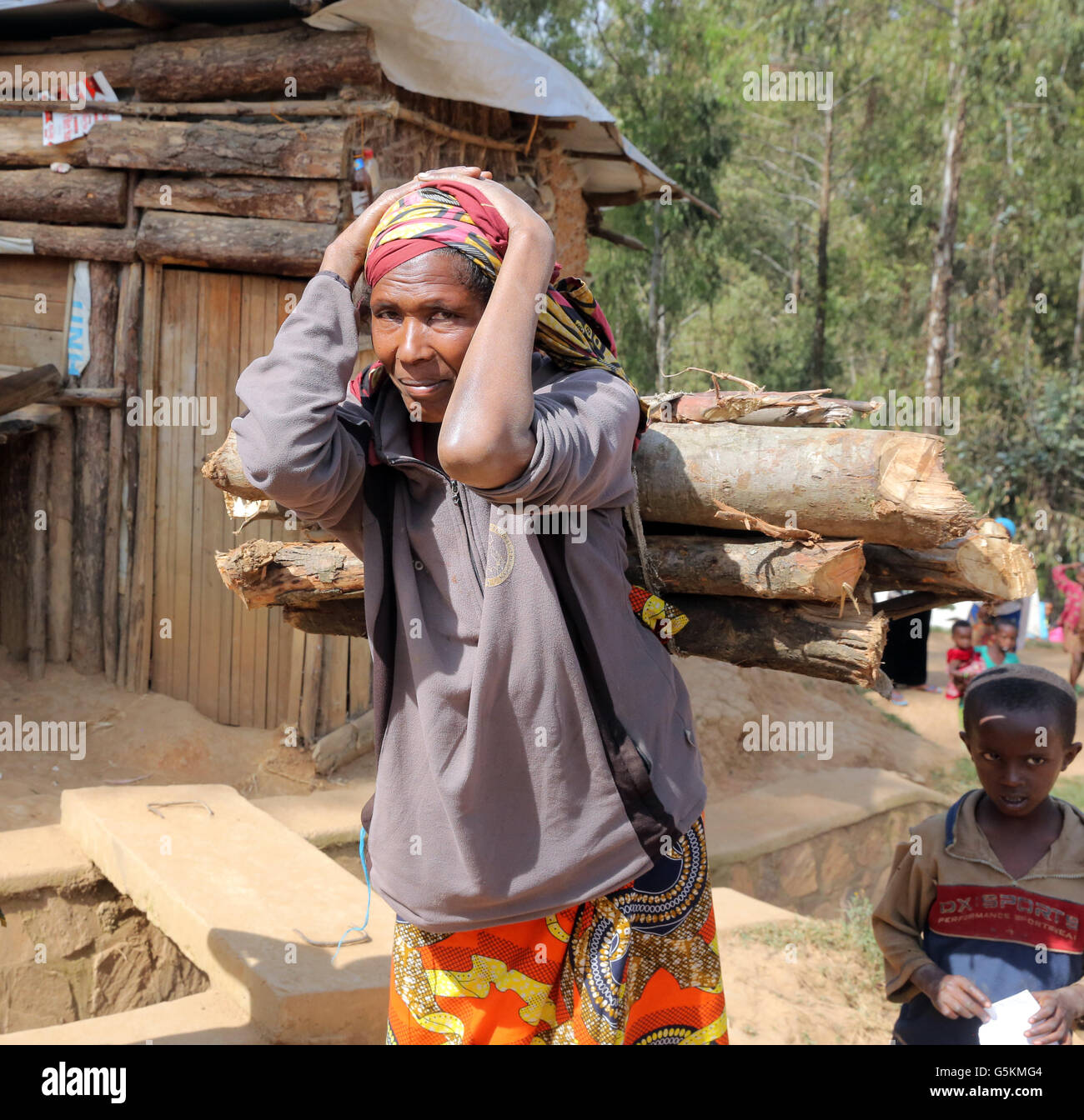 Flüchtling Frau aus dem Kongo, die Brennholz auf seinem Kopf trägt. Refugee Camp Kigeme in der Nähe von Gikongoro, Ruanda, Afrika Stockfoto