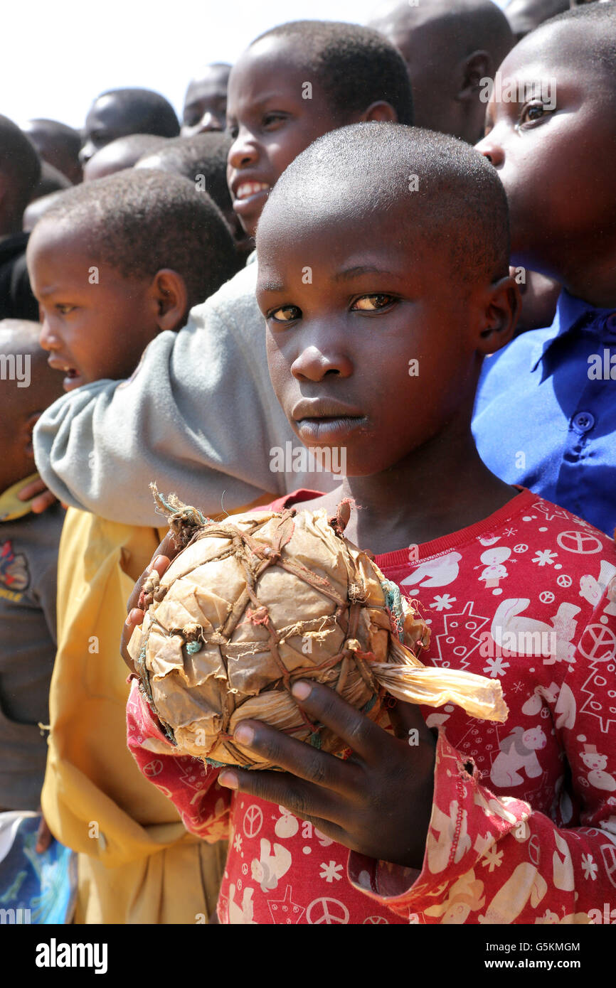 Junge (10 Jahre) mit seinem selbstgebauten Fußball gemacht aus Stofffetzen und Plastiktüten in einem Dorf in der Provinz Gikongoro, Ruanda, Afrika Stockfoto