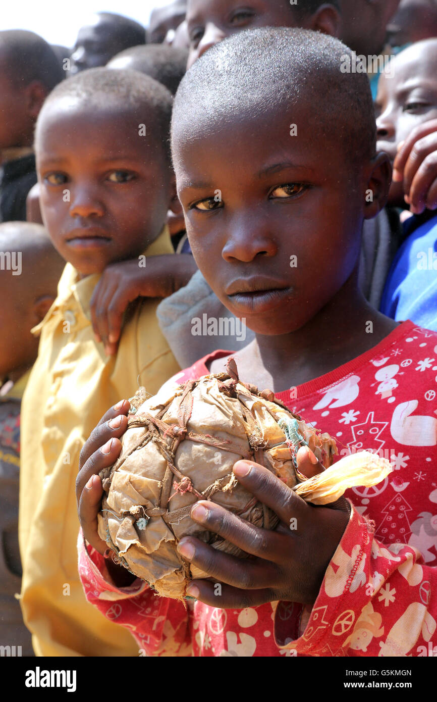 Junge (10 Jahre) mit seinem selbstgebauten Fußball gemacht aus Stofffetzen und Plastiktüten in einem Dorf in der Provinz Gikongoro, Ruanda, Afrika Stockfoto