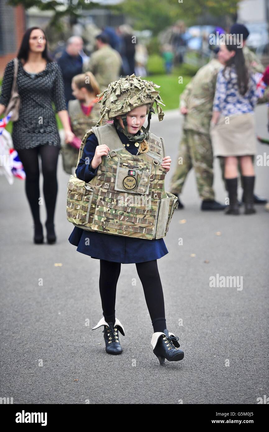 Courtney Evans, 10 Jahre alt, fährt mit dem Helm und der Körperrüstung ihres Vaters zum Auto, als Soldaten des 19. Regiments Royal Artillery (The Highland Gunners) nach der Rückkehr aus Afghanistan in die Tidworth Barracks mit ihren Familien wieder vereint werden. Stockfoto