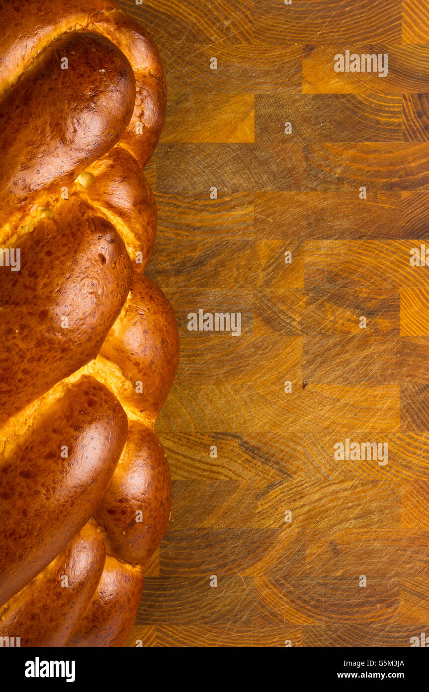 Brocken großes geflochtenes Brot auf hölzernen Hintergrund Stockfoto