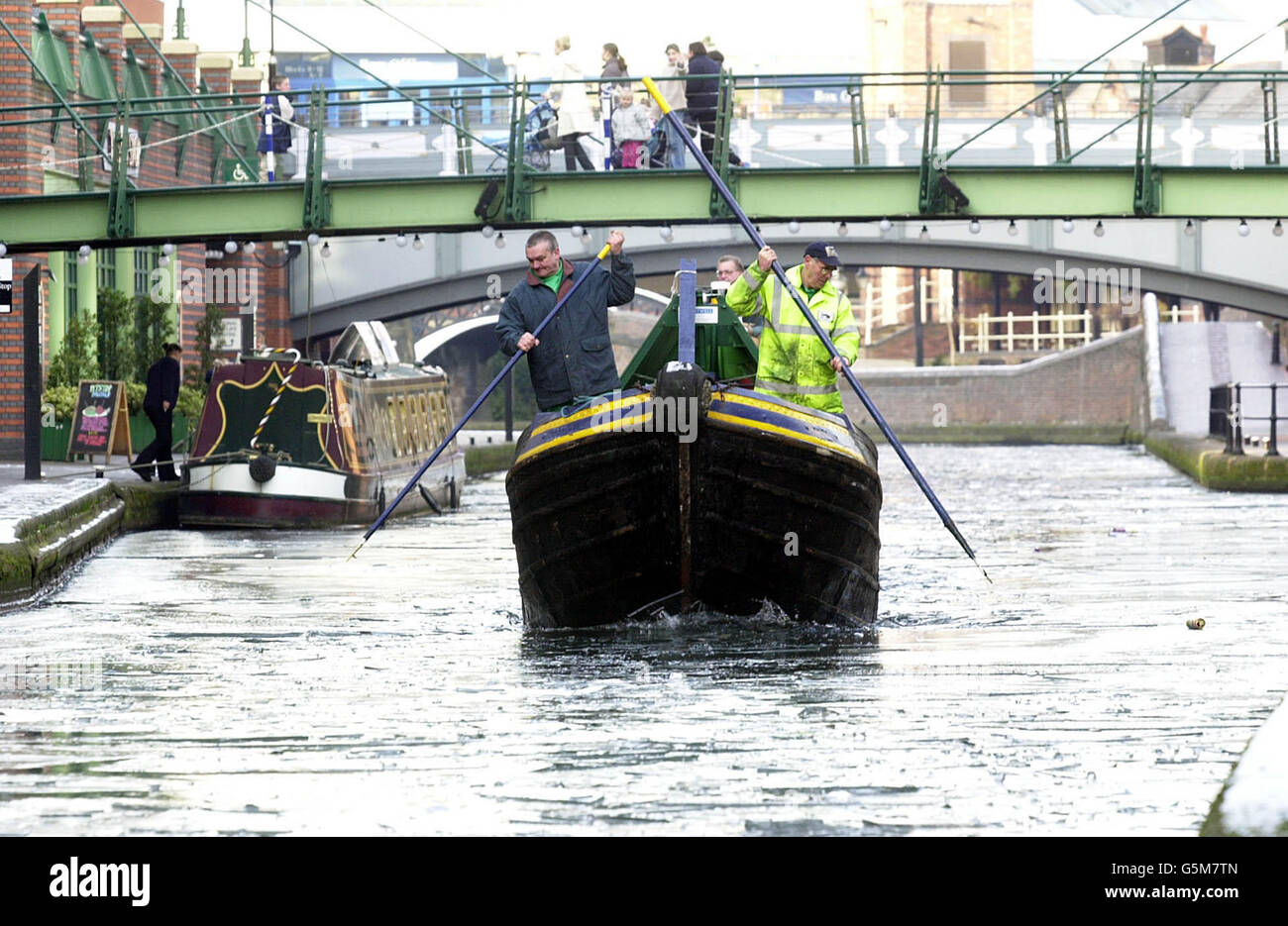 Das Barnett, das Eisbrecherboot der British Waterways, fährt am Brindley Place in Birmingham durch das Eis. Mit traditionellen Schmalbooten mit V-förmigem Bug brechen Teams von Ingenieuren Eisschwaden auf, die Teile des britischen 2,000-Meilen-Kanalnetzes eingefroren haben. Stockfoto