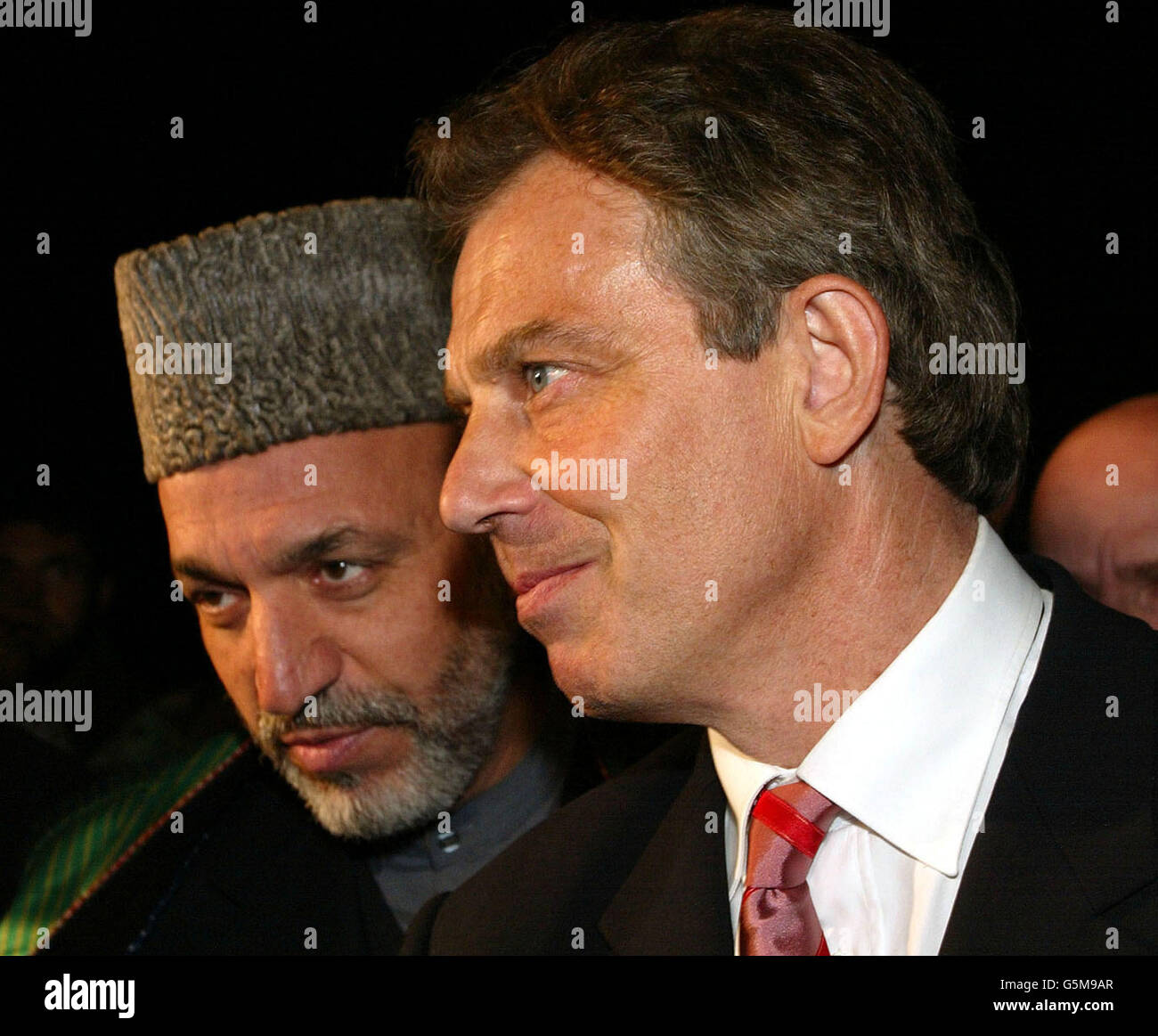 Der britische Premierminister Tony Blair (R) tritt bei seiner Ankunft auf dem Luftstützpunkt Bagram mit dem afghanischen Interimsführer Hamid Karzai zusammen. Blair flog am Montag nach Afghanistan und wurde damit der erste westliche Regierungschef, der das Land seit dem Sturz des Taliban-Regimes besuchte. Stockfoto