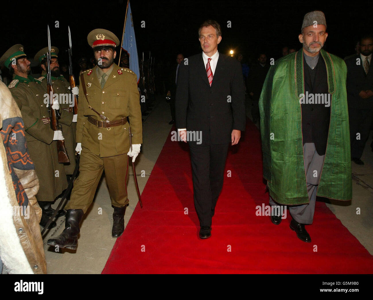 Der britische Premierminister Tony Blair (L) tritt bei seiner Ankunft auf dem Luftstützpunkt Bagram mit dem afghanischen Interimsführer Hamid Karzai (R) zusammen. Blair flog am Montag nach Afghanistan und wurde damit der erste westliche Regierungschef, der das Land seit dem Sturz des Taliban-Regimes besuchte. Stockfoto