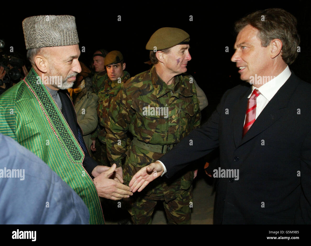 Der britische Premierminister Tony Blair (R) trifft bei seiner Ankunft auf dem Luftstützpunkt Bagram mit dem afghanischen Interimsführer Hamid Karzai zusammen. Blair flog am Montag in Afghanistan ein und wurde der erste westliche Regierungschef, der das Land seit dem Sturz des Taliban-Regimes besuchte. Stockfoto