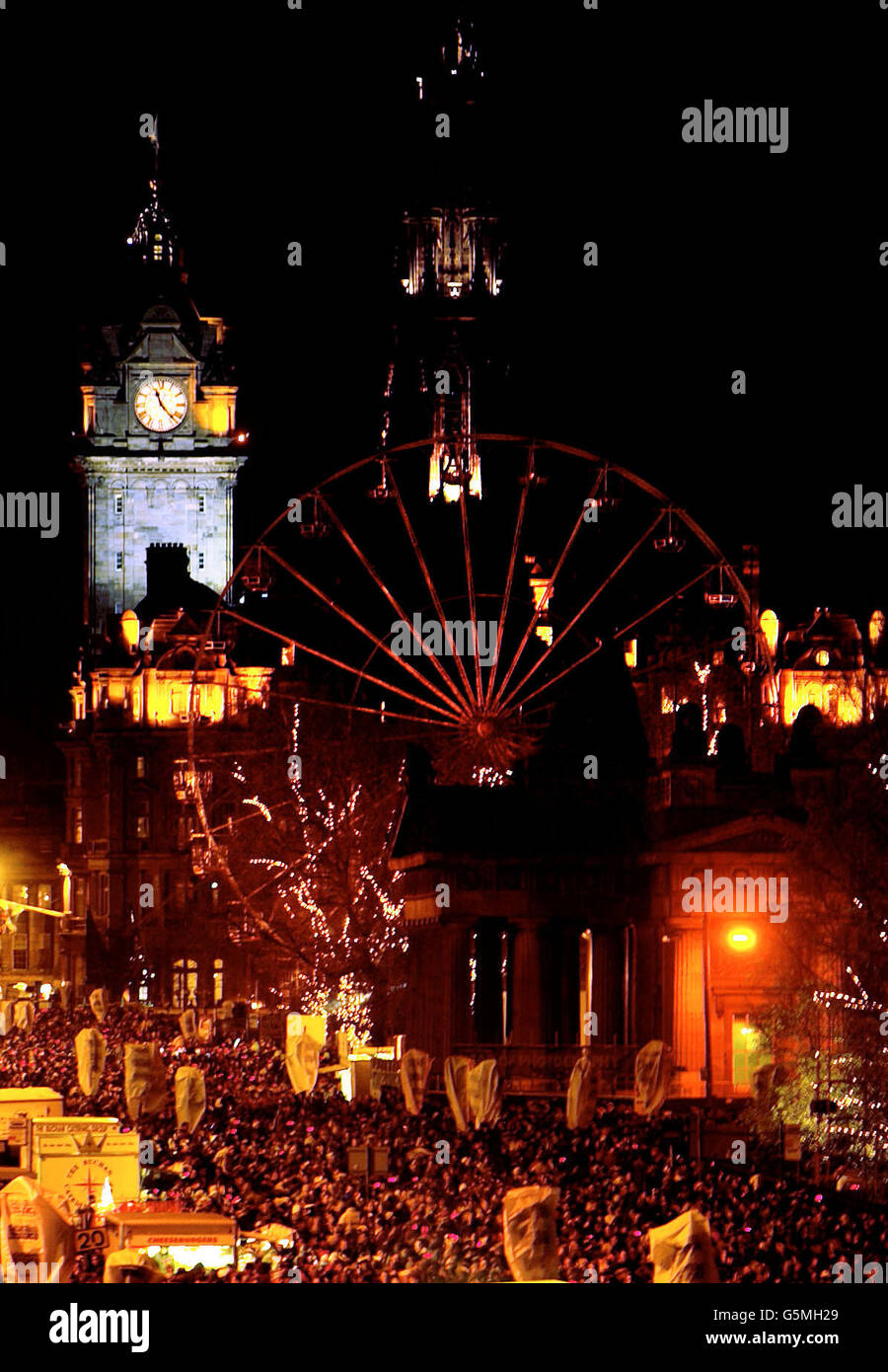 Silvester-Nachtschwärmer treffen sich in Edinburghs Princes Street. 31/12/02 : Festliche Feiernden in Schottland bereiten sich auf ihre Hogmanay-Feierlichkeiten vor, die als eine der größten Nächte des Jahres nördlich der Grenze gelten. Tausende von Menschen aus der ganzen Welt gingen in Pubs, Clubs und Straßen in ganz Schottland. Edinburgh ist nach wie vor der beliebteste Ort für Partygänger mit der weltberühmten Princes Street, einem der Highlights des Landes. Stockfoto