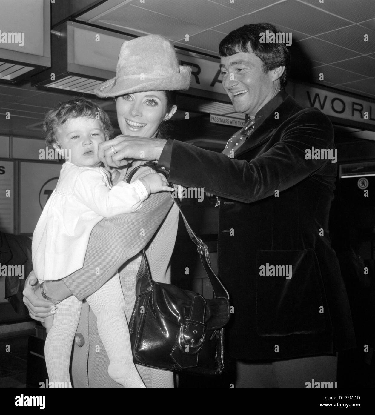 Der britische Friseur Vidal Sassoon mit seiner Frau, der amerikanischen Schauspielerin Beverley Adams und ihrer einjährigen Tochter Catya am Londoner Flughafen Heathrow. Stockfoto
