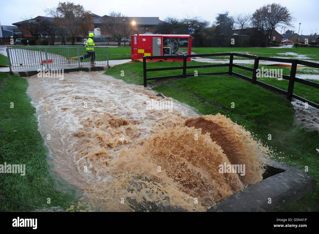 Feuerwehrleute bereiten sich darauf vor, Wasser aus einem Beck hinter dem Friarage Hospital in Northallerton, North Yorkshire, zu Pumpen, während der starke Regen in ganz Großbritannien weitergeht. Stockfoto